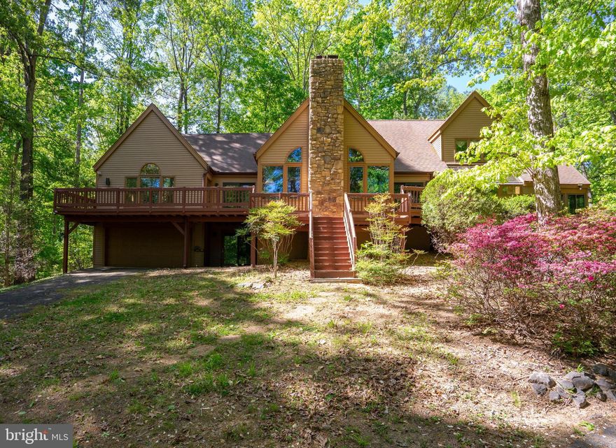 4,000 Square Feet. Private Dock. Public Side of Lake Anna. This Is the One.

Some homes are a place to sleep. This one is a place to live. Situated on one of the most desirable stretches of Lake Anna's public side, 54 Tara Circle is a 4-bedroom, 3.5-bath, three-story waterfront home with roughly 4,000 square feet of thoughtfully finished living space, and a private dock where the best version of your summers begins.

Arrive via a paved driveway with ample guest parking. Step inside to a foyer that immediately sets the tone: soaring windows frame the lake like a painting, and a striking stone fireplace anchors the main living room with warmth and presence. The open layout flows into a dining area and a generously appointed kitchen with abundant cabinetry and a perfectly positioned window that frames the water and floods the room with natural light. A second living space just off the main area features custom built-in cabinetry, ideal for a media room, game space, or a quiet gathering spot. An enclosed indoor-outdoor room extends the seasons, giving you the feel of the outdoors without leaving the comfort of the home. Laundry is conveniently located on this level.

On the main level you'll also find a versatile bedroom, perfect as a guest suite or dedicated office, and the primary suite, complete with private lakefront views and a spacious en-suite bath.

Upstairs, two additional bedrooms and a full bath are beautifully finished and full of character. The oversized landing overlooks both the main level and the lake beyond, making it a natural perch for a reading nook or home office. A bonus room and unfinished expansion space round out this level, ready for your vision.
The walkout lower level was built for entertaining: a bar, custom built-ins, full bath, and direct access to the garage and backyard create a natural flow from indoor to outdoor living,  and straight to the water.

Outside, your private dock sits on some of the most coveted shoreline on the public side of Lake Anna. Launch a boat, kayak the cove, fish from the pier at sunrise, or simply sit at the water's edge and let the lake work its magic. The public side means waterfront dining, marinas, and full lake recreation are all within reach by boat.

High-speed internet available. Move-in ready. Schedule your private tour today, and watch the video tour to see it all come to life.