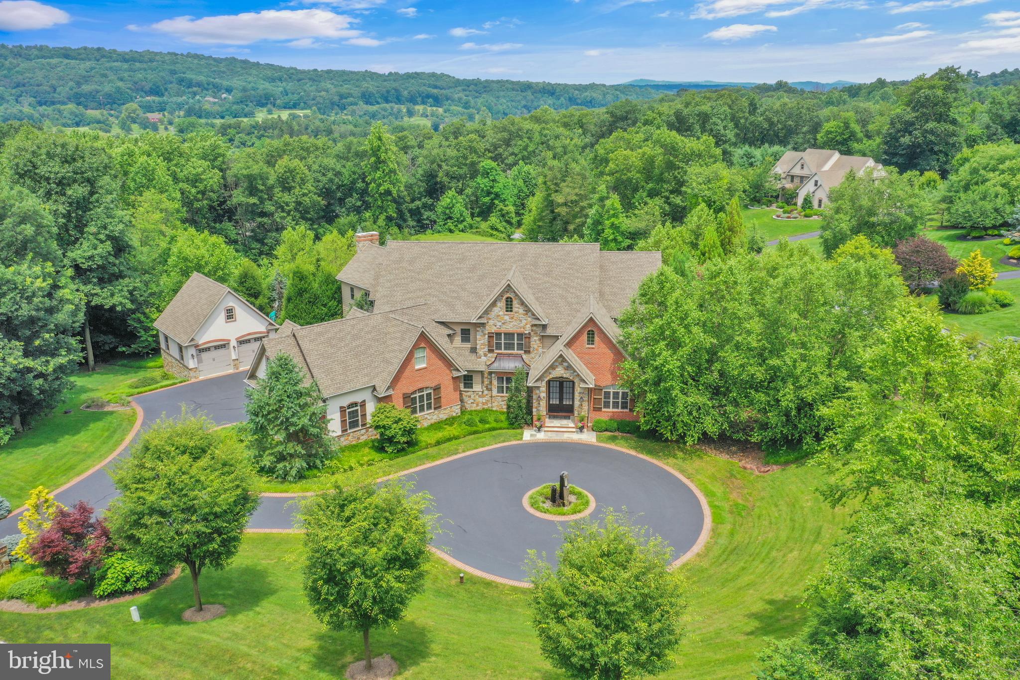 Welcome to 32 Stonehill, where unparalleled luxury meets serene living in this magnificent 8-bedroom, 8-bathroom (6 full, 2 half) single-family residence in the rolling hills of Cumru Township. Built in 2015 by Elite Home Builders, this transitional architectural masterpiece spans an impressive 8,854 total square feet (6,165 finished above grade, 2,689 finished below grade) and sits majestically on a private 3.03-acre lot, featuring mature landscaping and a resort quality outdoor living space all directly across from the renowned LedgeRock Golf Club. Step inside and be captivated by the grand scale and refined details. The home boasts six fireplaces, offering warmth and ambiance throughout and the luxury chef's eat-in kitchen is a culinary dream, featuring a commercial-grade stainless steel six-burner stove, double ovens, a huge island perfect for entertaining, a walk-in pantry, and a built-in dining nook. This expansive residence offers multiple living and entertaining spaces across three levels, each with covered porches and balconies. The main level also includes a formal dining room, a spacious living room with a vaulted ceiling and balcony access, a den & separate office and a family room with coffered ceiling and charming built-ins and a wet bar. The main floor also houses a spacious guest bedroom with full en-suite bathroom that could function as a primary bedroom. The upper level is home to the luxurious primary suite, a private oasis with an attached bathroom, jetted tub, walk-in shower, gas fireplace, built-ins, and balcony access and a spacious walk-in closet. Four additional generously sized bedrooms, each with attached bathrooms (totaling 6 bedrooms with en-suite baths), and an upper-level laundry room which can also be accessed from the primary closet completes this floor. The finished walk-out lower level is an entertainer's delight, featuring a game room with a fireplace, 2 additional bedrooms with an attached bathroom, a movie theater, stunning wine cellar, full bar, and a pool mudroom with additional bathroom. This level offers endless possibilities for recreation, a home gym, or an in-law suite and also houses a 2nd laundry for convenience. Step outside and truly experience resort-style living. The property boasts a private, fenced and heated in-ground gunite Infinity Edge Pool with an integrated hot tub, slide, grotto, sun deck, fire bowls, and swim-up bar. The massive flagstone patios feature a large fire table, a wood-burning fireplace, and a pizza oven. A full outdoor kitchen offers top-of-the-line appliances, including a gas grill and warming drawer. The expansive offering includes 2 lots totaling 3.03-acres and provides a scenic vista with tranquil views of trees and woods, offering privacy and a connection to nature. There is also potential to build a 2nd home on the additional lot if you have a multi-generational need for a 2nd residence next door.
Additional premium features include geothermal heating and cooling for energy efficiency, a full home water filtration system with reverse osmosis, 400amp electric service, two tankless water heaters, and a 200 amp backup generator. Full smart home automation controls media, sound, lighting, and climate. For security and peace of mind, the home is equipped with a 24-hour security system and exterior cameras. Parking is also abundant with a 5-car garage (attached and detached options), a circular driveway, and ample open parking spaces. Located in the desirable Governor Mifflin School District, this property offers easy access to local amenities and attractions. Mohnton is a charming community close to various outdoor recreation areas like Nolde Forest Environmental Education Center, Blue Marsh Lake, and numerous golf courses. Enjoy proximity to cultural attractions in Berks County including the Santander Arena and GoggleWorks Center for the Arts. Don't miss the opportunity to own this exceptional estate.