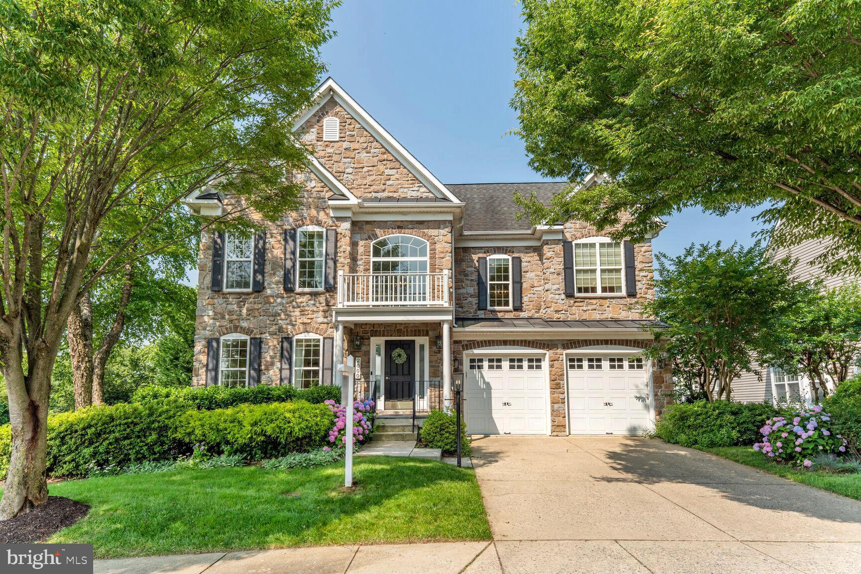 Welcome to this former model home in the exclusive Monticello enclave—just steps from restaurants and shopping. Offering over 6,500 sq ft of refined living space across three levels, this beautifully maintained residence features a dramatic two-story foyer with black-and-white marble flooring and designer lighting. The chef’s kitchen boasts high-end appliances, quartz waterfall counters, and opens seamlessly to the family and breakfast rooms, with two decks for outdoor enjoyment.
The main-level ensuite bedroom is ideal for guests or multigenerational living. Upstairs, the luxurious Primary Suite includes a sitting room with fireplace, private balcony, spa bath, and bonus space for an office, gym, or nursery. Three additional bedrooms and 2 full baths complete the upper level. The fully finished lower level includes a with a wet bar, rec room, theater, and flexible bonus suite. Additional perks include a 2-car garage, ample storage, and access to Monticello’s pool and dog park.