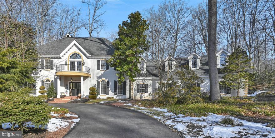 If you’re seeking a truly custom-built home with exceptional craftsmanship and timeless architectural detail, this stunning French Provincial two-story delivers at every turn. Privately nestled on a 2.5-acre wooded lot, this remarkable residence offers over 6,000 square feet of living space and a three-car garage, blending elegance, comfort, and privacy. Enter through grand double doors into a breathtaking two-story foyer featuring ceramic tile flooring and intricate dentil crown molding. The foyer opens seamlessly to the formal dining/billiards room adorned with oak hardwood floors, dentil crown molding, chair rail detailing, and arched windows that flood the space with natural light. The first floor offers exceptional versatility with a bedroom and ensuite full bath, ideal for guests or multi-generational living, along with a private office showcasing paneled walls and crown molding. The living room is warm and inviting with hardwood floors, dentil crown molding, a gas fireplace, and large arched windows overlooking the serene backyard. The expansive kitchen features stainless steel appliances, an oversized pantry, and an eat-in area with custom shelving—perfect for everyday living and entertaining. Adjacent is the dramatic two-story family room with a wood-burning stove, floor-to-ceiling stone surround, and a stunning tongue-and-groove wood ceiling. A four-season sunroom provides peaceful views of the patio and surrounding woods.  Also on the main level are a laundry room and half bath for added convenience. The primary suite is a rustic retreat complete with a gas fireplace, spa-inspired ensuite bath with double vanities, tile walk-in shower, deep soaking tub, and a spacious walk-in closet. The second floor also features three additional oversized bedrooms and two full baths, along with abundant storage throughout the home. The finished lower level is the perfect game room and theater area with projector tv, great for family movie nights or hosting parties for the big sports games. Outdoor living is just as impressive, with a covered patio, additional patio areas, and a storage shed—ideal for relaxing or entertaining in total privacy. Perfectly secluded yet conveniently located with easy access to Hershey, Harrisburg, and Lancaster, this exceptional home offers luxury living in a tranquil setting.