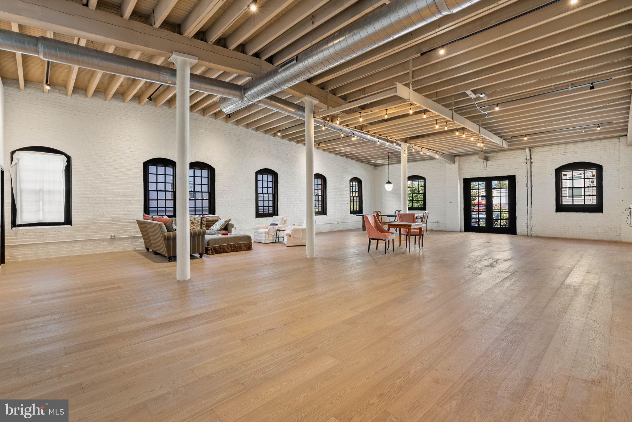 Welcome to this 7,000 SqFt New York–style loft residence with dramatic open spaces, vaulted ceilings, a deck, and 3-car secured attached garage parking! There is no space available in the marketplace like this one. Designed with a modern open floor plan, this home offers an airy, loft-like atmosphere featuring soaring ceilings and expansive windows that flood the space with natural light. Basketball court, theater, spa, artist space—this space can accommodate it all! Gorgeous upgrades have already been completed, with plenty of opportunity remaining to add your personal style. The sleek industrial aesthetic is complemented by exposed steel and wood beams and rich hardwood flooring that flows seamlessly throughout much of the home. Separate the space into two private areas if you choose—the large barn-style doors are already in place to divide the space into two residences, or a work side and a play side! Step out onto your private deck for outdoor relaxation, and enjoy the rare convenience of 3-car secure garage parking. Thoughtfully renovated in key areas, this home also presents a rare opportunity for buyers to bring their vision to life and fit out the extra spaces to suit their own taste and lifestyle. This unit is part of a larger building and will be sold off as part of a 3-unit association. Taxes and square footage is the responsibility of the buyer to have verified independently. Association fees are TBD.