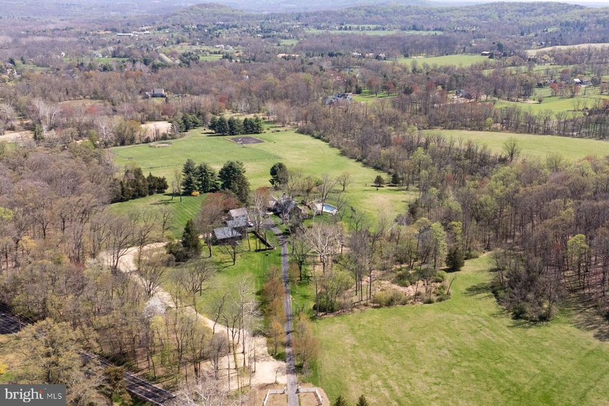 A treelined driveway takes you to a piece of Heaven on 53+ acres of rural beauty with its natural woodland & complementing pasture. Seldom is a property offered enjoying the trappings of a breathtaking location, outstanding supporting real estate, privacy & a residence that is Simply & Stunningly Elegant! Gracious 18th century pointed stone & frame farmhouse is tucked away on one of Upper Makefield Township’s coveted roads of unparalleled open space & enjoys the wonderful company of rolling farmland & fine estate properties. Verdant vistas have not changed much over the last 2 centuries. Warm, inviting & comfortable, this meticulously maintained home looks across sprawling rolling fields, a captivating view of Bowman’s Hill & bucolic countryside in the distance. Quality is a hallmark of this exceptional property. If it’s “all in the details”, you will easily appreciate the many subtle refinements & consistent use of exceptional materials chosen by its owner’s discerning eye, creating balance, relaxed sophistication & a great grasp of aesthetics. Finely milled woodwork & extensive use of solid mahogany floors throughout. Appealing stone, marble, imported wallcoverings, exceptional European lighting & plumbing fixtures capture your senses, providing seamless balance & pleasant surroundings. Enjoy ever-changing seasons offered by the excellent placement of windows. The foyer & its uncommon, raised panel arched doorways welcome you & set the stage for a very pleasant experience. Living room of great proportion w/ its dual graceful staircase & large, mantled fireplace is complimented by captivating hand painted scenes of the Turkish Bosporus waterway.  Formal dining rm. w/ cut stone mantled fireplace features raised paneling, subtle gouge woodwork & corner cupboard. Well-planned gourmet kitchen will please the most accomplished chef w/ its large center island. Your eye is drawn to an exposed fieldstone wall, generous raised panel cabinetry & soapstone counters. Appliances include Wolf, Sub-Zero & Bosch. Adjacent pantry w/ wet bar, abundant cabinetry & under storage includes double prep. counters offers additional workspace & is conveniently positioned between dining room & kitchen. Breakfast area w/ wrap around window & French door leads to a flagstone patio & lovely view of the pool and wooded hillside. Family room complimented w/ barrel ceiling & window of sizeable proportion & extensive raised panel cabinetry offers a great space for intimate entertainment. Den/study is perfect place to curl up with a book & relax on a winter’s day. Enclosed screened flagstone porch allows outdoor seasonal dining.  Primary bedroom suite w/ mantled fireplace opens onto a rooftop deck. It offers a luxurious marble bath w/ custom oversized shower, dressing area & 2 custom designed walk-in closets w/ organizers. There are 3 additional bright & cheerful bedrooms, plus 2 classic marble & tile baths completing second floor. Third floor offers a spacious bedroom/flex space w/half bath. Wonderfully private setting surrounds heated in-ground pool, set amongst blue stone aprons, walkways & patio areas for soaking in the sun & summer soirees.  Charming carriage house offers heated 3 bay garage as well as potential studio space above. Stone & frame barn makes a perfect place for your favorite pets & animals. An impressive list of “top of the line” newly installed materials were chosen. Use of premium wood roof shingles, standing copper roofs, gutters & downspouts add both physical & aesthetic value to this marvelous home. There is a noteworthy high output “Whole House” generator. “State of the art” plumbing, electrical, zoned heating & air conditioning systems are quite impressive! List of exceptional recent improvements & refinements are numerous to mention. A Sensational place for Entertaining, Sharing & Celebrating life! Come see why this Extraordinary Home & Property is one of Bucks County’s finest offerings available!