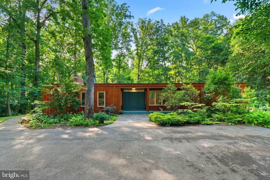 Ensconced by a canopy of trees on a 2 acre homesite with a circular drive approach, you find a wide
Bluestone walkway introducing this eye-catching contemporary style residence featuring over 3,082 sqft,
reclaimed heart pine wood flooring, an inviting foyer, and rejuvenating natural light throughout.
Living among nature is a breeze in this home featuring a blue stone surround fireplace centering a formal
living room that flows into the open dining room, both with glass sliders stepping to a covered deck
followed by an entertaining family room positioned next to the kitchen with a wall of windows framing
the peaceful outdoors, and a perfect view of the high-end kitchen.  Enjoy all of your culinary favorites in this beautifully appointed gourmet kitchen boasting top of the line GE Monogram stainless steel appliance suite with cabinet fronts including a French door wall oven and an induction cooktop, exotic marble counters, raised panel wood cabinetry, a farmhouse sink, a skylight, and plenty of table space.
Three bedrooms are situated on the main level including two ensuite bedrooms, one with a huge walk-in
closet, a sitting area and rich hardwoods, all with striking views bringing nature inside.
Exceptional living space is found downstairs highlighted by a rec room, a bedroom, a full bath with separate entrance, a sizeable laundry room finished with stone flooring, full sized windows, extra space for storage, and a walkout to the rear blue stone patio and yard. Exterior amenities include a front porch, a blue stone patio, a relaxing side porch, a rear deck, gently placed stone boulders lead from the front to the backyard, shady mature dogwoods and oak trees, and a wonderful address close to dining, golf, shopping, and commuter routes.