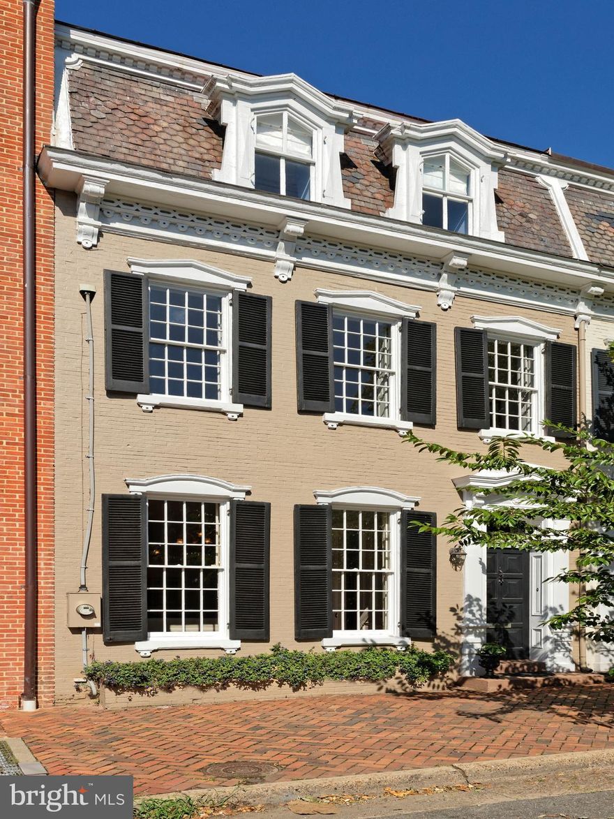 This important historic home, circa 1840, features a gorgeous living room with 11 foot ceilings, 12 over 12 tall windows, a handsome marble fireplace, original entrance doors and original pine floors.  The inviting dining room with wainscoting, a crystal chandelier and  fireplace is a perfect size and setting for a dinner party.   The renovated chef's kitchen with marble countertops and back splash, designer lighting and top-of-the-line appliances is sunny and bright.  There is a casual eating counter in front of the  window looking toward the patio.  Upstairs you'll find 4 spacious bedrooms, 3 updated  baths, a fabulous master suite with a walk-in custom designed closet and original windows in each room.  The master spa-like bath offers a  claw foot tub.   There is also a sitting room on the second floor.  Guest rooms and /or office are found on the top floor, with more custom built-ins.   The lower level family room with TV space and desk space is a cozy spot.    A lovely brick patio awaits for cocktails.  One block from King Street,  Market Square  many restaurants and a short walk to interesting shops.