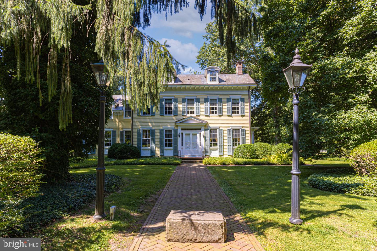 Explore this classic 1800s farmhouse where historic beauty meets an incomparable setting. Enjoy canal access which provides an easy walk to Yardley Boro as well as breathtaking river views . Situated on a gorgeous large double lot this stately home is pleasing both inside and out. The beautiful herringbone patterned front brick walkway lends a welcoming feel as you approach this charming 3-story original structure home accented with grand gables, multiple brick chimneys, detailed millwork and rear tin roof. The stunning walkway’s beauty continues around to a covered entrance on the side flanked with architectural columns and craftsman styled built-in benches for that desired resting place or just a place to put down those bags of groceries while opening the door. Enter the handsome study with wood-paneled bookcases and fireplace offering a perfect niche for warmth and reading. The front living room is simply grand offering plenty of space for hosting family gatherings with its 9 ft. ceilings, column adorn walls, colonial style fireplace and numerous large windows allowing for sun-filled ambiance. An adjacent formal dining room with its planked wide hardwood floors adds to the convenient entertainment flow along with the connected kitchen which is accessed by a unique swing door. The kitchen boasts an expansive and central prep island with second sink, three walls of storage cabinetry and a large bay window showcasing scenic views of the backyard’s park-like setting. A nearby sitting room leads to a sizeable raised brick patio with sweeping vistas of gardens and woods beyond. A main floor half bath, laundry/mud room outfitted with additional storage space are convenient amenities. Two separate staircases from the main floor will lead you to the upper level, which hosts all four bedrooms, including the cozy primary suite. The open suite with its colonial style fireplace, detailed moldings and trim work enjoys a roomy bath making this space a truly calming experience. Two additional spacious bedrooms, a relaxing princess suite with a convenient full bath and hallway access, a library adorn with custom bookcases containing several hidden compartments and a third full bath complete the second level. Dormers bring charisma and light to the uppermost level offering endless possibilities. This A short drive to charming town centers, restaurants and shopping venues and just minutes from famed Washington Crossing, PA, move right into this riverside haven brimming with historic character and begin enjoying a river based lifestyle!