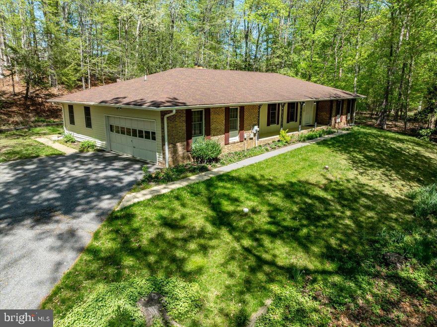 In the heart of Davidsonville’s coveted Harbor Hills, where wooded slopes cradle the edge of the South River, a rare opportunity presents itself.

Set back on a private drive and spanning just over 1.3 acres, this alluring 4-bedroom, 3-bath home offers a harmonious blend of natural serenity and thoughtful design. The versatile fourth bedroom—complete with its own sink, dishwasher, and countertop—lends itself effortlessly to an in-law suite, guest quarters, or creative studio retreat.

The kitchen is built for everyday living, with plenty of cabinet space to keep things organized and stainless steel appliances that are durable, modern, and attractive. It’s a comfortable space that works just as well for weeknight dinners as it does for weekend get-togethers. It opens up to a roomy living area overlooking the front yard that changes beautifully with the seasons.

Surrounded by nature at every turn, the home’s layout invites both quiet reflection and connection. A generous front yard, framed by towering trees, sets the stage for peaceful mornings and lively gatherings alike. The All Seasons Room beckons you to take in panoramic woodland views year-round, while a fireplace brings warmth and comfort indoors. Beneath it all, a spacious, partially framed unfinished basement awaits your personal touch.

Balancing its tranquil setting with everyday comfort, the home also features a two-car garage and an expansive driveway, accommodating 8–10 vehicles—an uncommon convenience in such a private location.

Life in Harbor Hills flows with the soothing rhythm of the river and the gentle rustle of leaves. Time seems to slow, allowing each day to unfold with a welcoming ease. Within this serene backdrop lies a vibrant, close-knit community where amenities abound: a sparkling pool, tennis and pickleball courts, a newly renovated waterfront clubhouse, a sandy beach with pavilion, playgrounds, ballfields, and a marina for those drawn to the water.

With just 185 homes nestled gently into the landscape, this premier waterfront enclave provides timeless charm, graceful elegance, and a true sense of seclusion. A hidden gem—off the beaten path—ready to welcome you home.