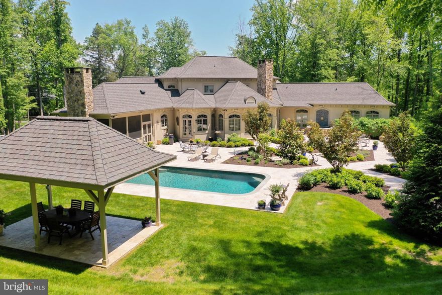 Wonderfully planned 9 year old custom home by Don Johnson on 5.25 acres with multiple ways to walk out to  level travertine stone areas  surrounded by gardens, a heated salt water pool, dining pavilion and grill, hot tub, outdoor fire pit and a most delightful  screened porch with fireplace and TV right off the kitchen.  Truly a special sunfilled home to enjoy in all the seasons.   Highest quality elements throughout the interior at every turn.  Decorative ironwork, high ceilings even in upper and lower levels, stone fireplaces, beamed ceilings in family  room and kitchen  which also features a secret office. A coveted main level primary bedroom w/2 walk-in closets and dual sinks and dual water closets in primary bath.    Upper level features two spacious bedroom suites w/full baths and walk-in closets (one with a computer nook!).     Great entertaining,  getaway spaces and bonus rooms to use as needed in the lower level with 9 1/2  foot ceilings.    Copious storage throughout with many custom built-ins, wine cellar,  storage rooms,  closets and two 2-car garages.     Top of the line appliances and lighting fixtures, pantry doors from Lille, France,  high-end systems including a generator, 3 geothermal systems and whole house audio system.     All this in the charming and convenient Stevenson/Wiltonwood neighborhood in Greenspring Valley with Stevenson Village shopping a short walk down the road and Greenspring Station, 695 and I83 within a  5-6  minute drive. Easy commute to the airport. Forest conservation easement marked by signs at rear and side of property. Truly rare to find a recently built custom home with every amenity indoor and out, in such a lovely, quiet and convenient location.