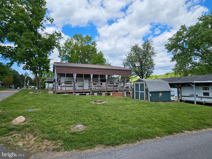 Impressively Large Corner Lot! Sitting on the corner of Campfire and Yogi Bear so no neighbors piled on top leaves plenty of room for parking or yard activities. Campfires, or cornhole whatever your heart desires. This lot features a large metal pavilion sitting on concrete posts, covering a 12*40 wooded deck, housing a 2005 40Ft Forrest River Wildwood Camper. Inside you'll find a Queen size bed on one end and a bunk room on the other with a set of twin bunkbeds. Some of the upgrades include a newer instant hot water heater, porcelain toilet, refrigerator, 2 electric massage chair recliners and a wooded table with bench seating and storage.  The camper has dual entry and a sliding glass door right to your porch to enjoy your coffee and listen to nature or take in the view of the Potomac River that is one block away. The Pavilion has curtains that snap together and looped to a wire so the wind can't blow them all over the place. Outside also has 3 ceiling fans with lights w/ remote to keep that warm summer breeze a flowing. There is an extra standard size refrigerator outside as well as a microwave tucked in the custom build cabinet. Everything you see conveys, all the patio furniture, shed, self-propelling push mower, rockers and more. There is a Brick raised bed for those who want pretty flowers or to plant some veggies. There is also a stone firepit for those campfires!
Riverbend is 400 Acres of SEASONAL recreational campground full of amenities located on the Potomac River in Falling Waters, Wv. OPEN APRIL 1 - NOVEMBER 1 - This is a fun & entertaining community, yet relaxing. 


Call today for your personal tour. Approx. 10 miles of Deep water on the Potomac River access for boating, fishing & swimming. Yearly membership ($1,987) plus a $200 initiation fee for new owners, includes water, sewer, electric, trash and the park amenities such as 3 pools, putt putt course, Horseshoe club, Boat club, Poker runs, Trick or Treat, Christmas in July, live bands, basketball court, tennis court, fireworks, car show, Church, restaurant, bar, convenience store (Great food), playground, volleyball, ball field and much much more. Join Riverbend Boat Club. Bring your golf carts, water toys and come enjoy life!