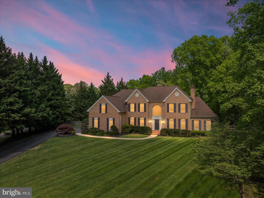 Some homes impress. Others stop you in your tracks. This is one of them. Set on two private acres in a secluded, pristine setting, this extraordinary 5-bedroom, 5.5-bath estate delivers refined luxury and effortless living at a level rarely seen—especially in this condition. Every inch has been thoughtfully reimagined through an extensive, high-end renovation, creating a completely turnkey experience where design, function, and craftsmanship align seamlessly.  At the heart of the home, a stunning reimagined gourmet kitchen anchors the main level, featuring a massive 12+ foot quartz island with seating for eight, premium Café appliances including a smart double oven, custom built-in pantry, designer lighting, and an adjoining wine bar with beverage fridge and curated storage. The space flows beautifully into a sun-drenched morning room and out to an expansive deck overlooking a private, fenced, level yard—perfectly suited for future pool plans and effortless indoor-outdoor living.  The family room is both dramatic and inviting with soaring vaulted ceilings and a floor-to-ceiling stone fireplace, while formal living spaces offer warmth, flexibility, and refined detail. A standout feature—added by the current owners—is the creation of a true main-level suite, designed for today’s lifestyle with solid wood pocket doors, a private lounge with custom bar, and a spa-quality bath with heated floors, rain shower, and designer finishes, offering exceptional flexibility for multi-generational living or a private guest retreat.  Upstairs, the owner’s suite is a destination unto itself, complete with a hotel-inspired sitting retreat with beverage bar, a fully customized boutique-style closet with center island, and a beautifully renovated spa bath with elevated finishes and thoughtful design. A private ensuite bedroom and a well-appointed Jack and Jill layout complete the upper level with both comfort and functionality in mind.  The fully finished walk-up lower level delivers exceptional entertaining space with a custom granite wet bar and expansive recreation areas. Daily living is elevated with a redesigned mudroom featuring custom built-ins, a fully renovated laundry room with floor-to-ceiling cabinetry, and a three-car side-load garage equipped with smart technology.  Extensive upgrades throughout include wide-plank hardwood flooring across both staircases and the entire upper level, custom closet systems in every bedroom, plantation shutters, designer lighting and fixtures, curated paint selections, and integrated smart home features including security, lighting, garage access, and water systems. Two brand-new high-efficiency Bosch heat pumps, whole-home water filtration, reverse osmosis system, and numerous mechanical upgrades ensure both comfort and peace of mind.  Surrounded by other fine homes and offering both privacy and prestige, this property remains incredibly convenient to Washington, Baltimore, Northern Virginia, and major airports. This is more than a home—it’s a statement, a retreat, and a rare opportunity to own something truly exceptional.