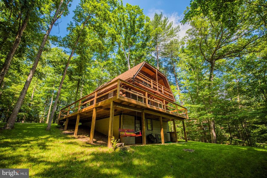 Lovely 3 level log home with waterfront on Sleepy Creek. Unfinished basement has room to expand, large wrap around deck with upper level privacy deck off the loft.  Main level bedroom, kitchen/dining combo and cozy family room that has 2 sliding doors onto deck.  Upper level has a bedroom, loft area with privacy deck and large bath.  About 20 min. to I-81 and Berkeley Springs.