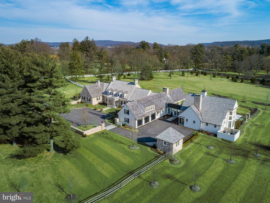 One of the most noteworthy properties to come on the market in a generation, Old Weyhill is an exceptional residence located on a private road, in the exclusive enclave of Old Weyhill, where Bethlehem Steel developed properties for their executives and guests. The legacy of the Old Weyhill community includes a nearby 1790 farmhouse, currently part of the Weyhill Guest Houses for the Saucon Valley Country Club. Befitting its name, this property is gracefully positioned in the middle of 6.8 acres, and sits amidst mature and specimen trees, with a rolling lawn overlooking quiet vistas.  Old Weyhill is a stunning grand estate, reminiscent of the country homes of the British Isles, surrounded by fields of green, enticing one to walk the acreage and stroll the private lane.  Inside, windows overlook multiple terraces and lawn, with pool and lanai, all within walking distance to the world class Weyhill Golf Course.  This gracious home is quality without compromise, an example of Saucon Valley’s best, and every bit as significant as its location. Old Weyhill is a re-imagined classic, executed with exceptional craftsmanship in the 2018 additions, redesign and reconstruction.  The new design is timeless, blending sophisticated details with contemporary vaulted spaces, in a whimsical and inviting ambience. At the center of all, the amazing design captures an elegance one would expect in a quintessential Saucon Valley estate property, where exquisite workmanship and detailed execution define each room. From the old-world courtyard, enter and be surprised by the expansive space, with attention to detail like no other, throughout every floor. Old Weyhill offers custom millwork and moldings, doors, locks and hardware, 4 fireplaces and a bounty of oversized windows and French and folding south-facing doors, providing great natural light.  Hosting significant gatherings with ease, each first floor room connects to the outside pool, patio and lanai. A fabulous post and beam, timber frame barn. with reclaimed wood, joins the original stone home through a glass enclosed breezeway, as if it was an original structure. This vaulted space will take your breath away.  A lower level game room and wine room are also part of the barn addition. The first floor master suite and exquisite bath are located in a gracious and elegant wing. On the second floor there are 3 additional bedrooms and 3 full baths and there is a separate second floor office and full bath that can also accommodate guests.  Finally, outside areas for intimate or formal gatherings abound. As further complement to this classic estate, the pool and spa have a heated lanai with woodburning fireplace, overlooking the landscaped gardens and vistas of the acreage beyond.  Once houses were built with grandeur and grace, with long driveways leading through expansive lawns, with rooms of grand proportions that flowed into each other, with wonderful attention to detail, exquisite woodwork, surprising accessories and all the accoutrements that made for ease of living.  They are rare now, but this gracious home is an example of the today’s best.