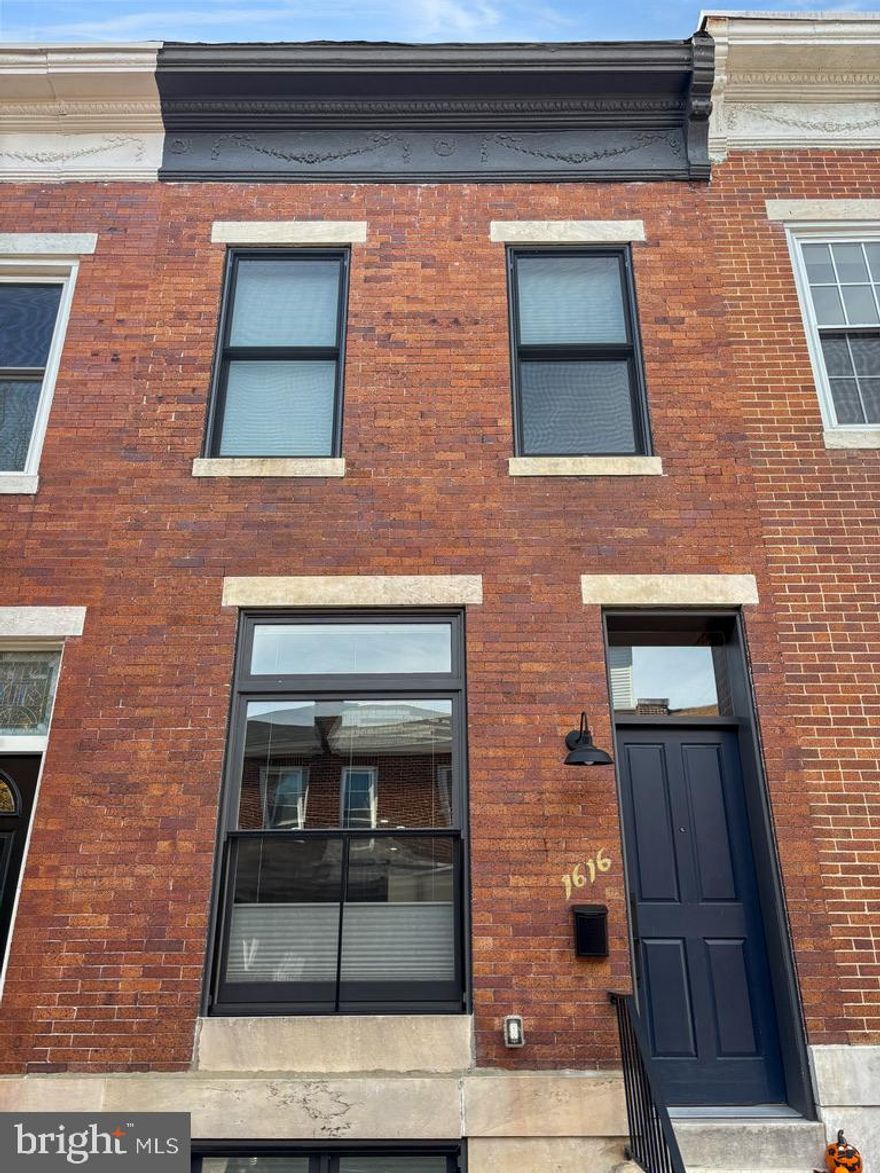 Welcome to 1616 Webster Street, a beautifully renovated 4-bedroom, 3-bathroom townhouse offering over 1,600 square feet of modern living in the heart of Baltimore’s desirable Riverside/Federal Hill neighborhood. Fully remodeled in 2021 by the highly regarded New Renaissance team, this home blends classic Baltimore charm with thoughtful modern updates. The main level features an open floor plan with original hardwood floors, exposed brick, and a spacious living area that flows seamlessly into the kitchen. The chef’s kitchen is equipped with stainless steel appliances, a built-in wine refrigerator, and a large island with seating—perfect for entertaining or everyday living. Upstairs, the second level includes a spacious primary suite with French door closets and a private en-suite bathroom with double vanity. An additional bedroom, full bathroom, and convenient stackable washer and dryer complete the level. The finished lower level offers even more flexible living space, including a third bedroom, full bathroom, and a fourth room ideal for a home office, gym, or guest space. Enjoy stunning views of the iconic Domino Sugar sign and the Baltimore skyline from the rooftop deck. The home also includes the rare convenience of a private rear parking pad. Located just steps from Riverside Park and minutes from Federal Hill’s restaurants, shops, nightlife, and waterfront.
