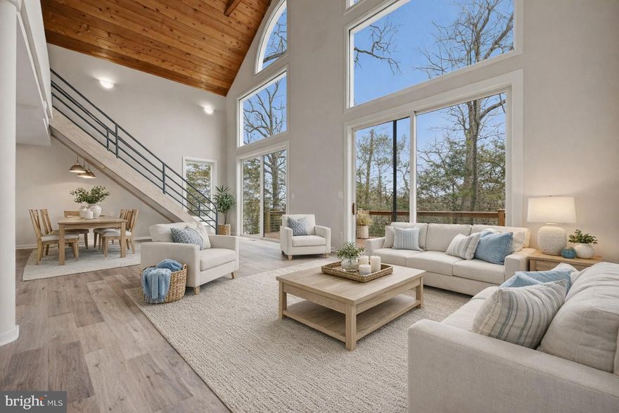 Welcome to 1717 Porters Hill Road, a light-filled contemporary home designed around volume and a seamless connection to its natural surroundings. Framed by expansive windows and soaring architectural lines, the home offers a fresh, airy interior where natural light moves beautifully throughout the day.
Inside, the main living spaces unfold with an open floor plan that feels both modern and inviting. Wide-plank flooring and warm wood accents create a clean, elevated backdrop, while dramatic windows and vaulted ceilings bring a sense of scale and calm. The living area is anchored by walls of glass that open to the surrounding decks, offering a peaceful, almost treehouse-like setting.
The home offers three bedrooms and two full bathrooms, including a convenient main-level bedroom that provides flexibility for guests, a home office, or single-level living. The kitchen is bright and streamlined, featuring white cabinetry, stainless steel appliances, a classic tile backsplash, and generous counter space. The relation to the main living and dining areas makes everyday living easy, while also creating an effortless flow for entertaining. Upstairs, two additional bedrooms share a hall bath, providing a thoughtful layout with private spaces tucked away from the main gathering areas.
Outdoor living is equally inviting, with an expansive deck wrapping around the home and overlooking Luce Creek. With 163 ft of waterfrontage, the sense of privacy is unmatched and offers ample opportunity to enjoy the surroundings. Super private location, but it’s a short drive to downtown Annapolis and commute routes.