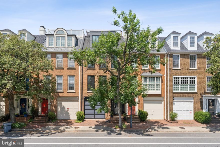 Stunning Fully Renovated Townhouse with Panoramic Rooftop Views

This colonial-style townhouse has been completely reimagined through a meticulous two-year, full stud-out renovation, blending timeless architecture with today’s modern luxury. From the herringbone floors and silver-leaf ceiling in the entry to the breathtaking 500 sq. ft. rooftop deck, no detail has been overlooked.

The main level showcases a thoughtfully expanded kitchen, featuring a quartz waterfall island, custom cabinetry with integrated Sub-Zero panels, hidden outlets, and a Wolf range. The open floor plan continues into the living room with custom paneled walls, a gas fireplace framed by a seamless 5x12 ft Calcutta ultra quartz slab, and bespoke seating with embossed leather accents. French doors lead to a blue stone patio, perfect for indoor-outdoor living.

The lower level offers a private guest suite with egress window, full bath, custom closet, and laundry. Upstairs, the primary bedroom suite features a spa-like marble bath with heated floors, floating European fixtures, and mirrored custom closets. An additional renovated full bath and bedroom complete the third floor.

The top level is an entertainer’s dream with a built-in bar, half bath, washer/dryer, and expanded waterfront views through oversized custom Pella windows. French doors open to a Brazilian Ipe hardwood landing with outdoor sauna, leading up to the reconceptualized roof deck. The roof deck provides unobstructed 365-degree views of the Potomac River, Old Town Alexandria, Woodrow Wilson Bridge, and even the U.S. Capitol.

Additional highlights include a garage and additional deeded parking space, all new 36x80 Pella windows and doors, a modern glass-paneled garage door, new HVAC system, and custom wire fencing. Every inch of this home has been crafted to create a one-of-a-kind residence that combines sophistication, comfort, and unparalleled views.