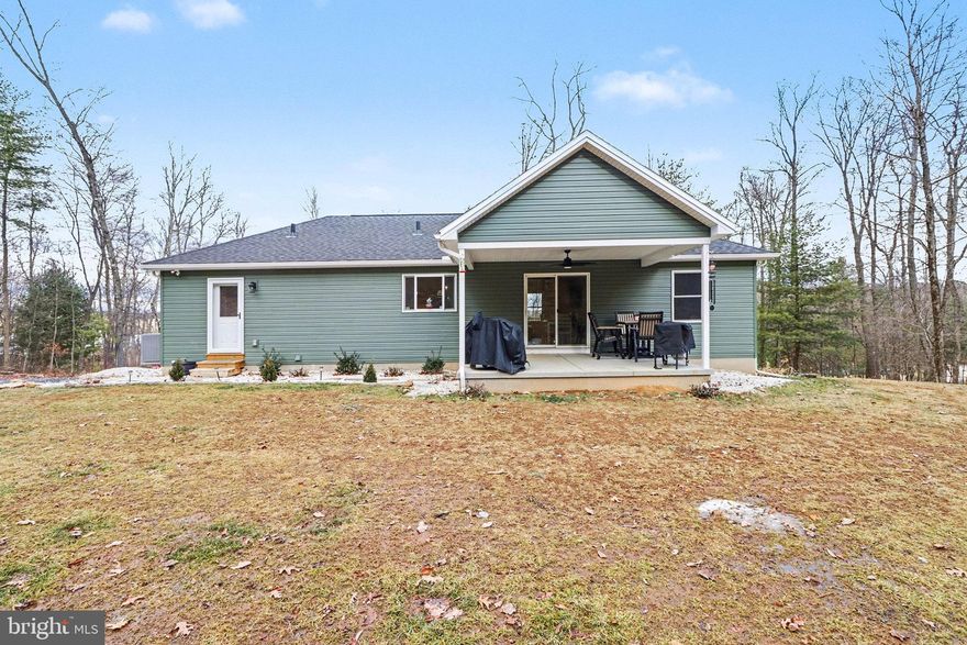 Custom-built in 2024, this thoughtfully designed property offers modern living on 10 scenic acres enrolled in Clean & Green! The main level features an open-concept layout with custom hickory cabinetry, a kitchen and dining combination, walk-in pantry, and a spacious living room. The owner’s suite includes a walk-in closet and full bath. A separate mudroom and laundry area are located on the main level for everyday convenience. The lower level is configured as a private in-law suite or apartment with its own separate entrance. This space includes a custom kitchen with hickory cabinets, dining area, living room highlighted by a three-window bay, a generously sized bedroom with a walk-in closet, and a full bath with a garden tub. A stackable washer and dryer are conveniently located within the bathroom, creating a fully self-contained living space. With a private entrance and independent layout, the in-law suite offers flexibility for multi-generational living, extended guests, or long-term and short-term rental uses. The in-law suite is equipped with mini-split heating and cooling systems, providing added comfort and convenience. The furnace has been prepped for connection to an outdoor wood burner, offering flexibility for alternative heating if desired.  Outdoor living is enhanced by both a covered front porch with mountain views and a covered rear patio overlooking the wooded surroundings. With ample room to explore, relax, and enjoy nature, this property offers privacy, versatility, and space rarely found. Schedule your tour today and experience the privacy, versatility, and natural beauty this property has to offer.