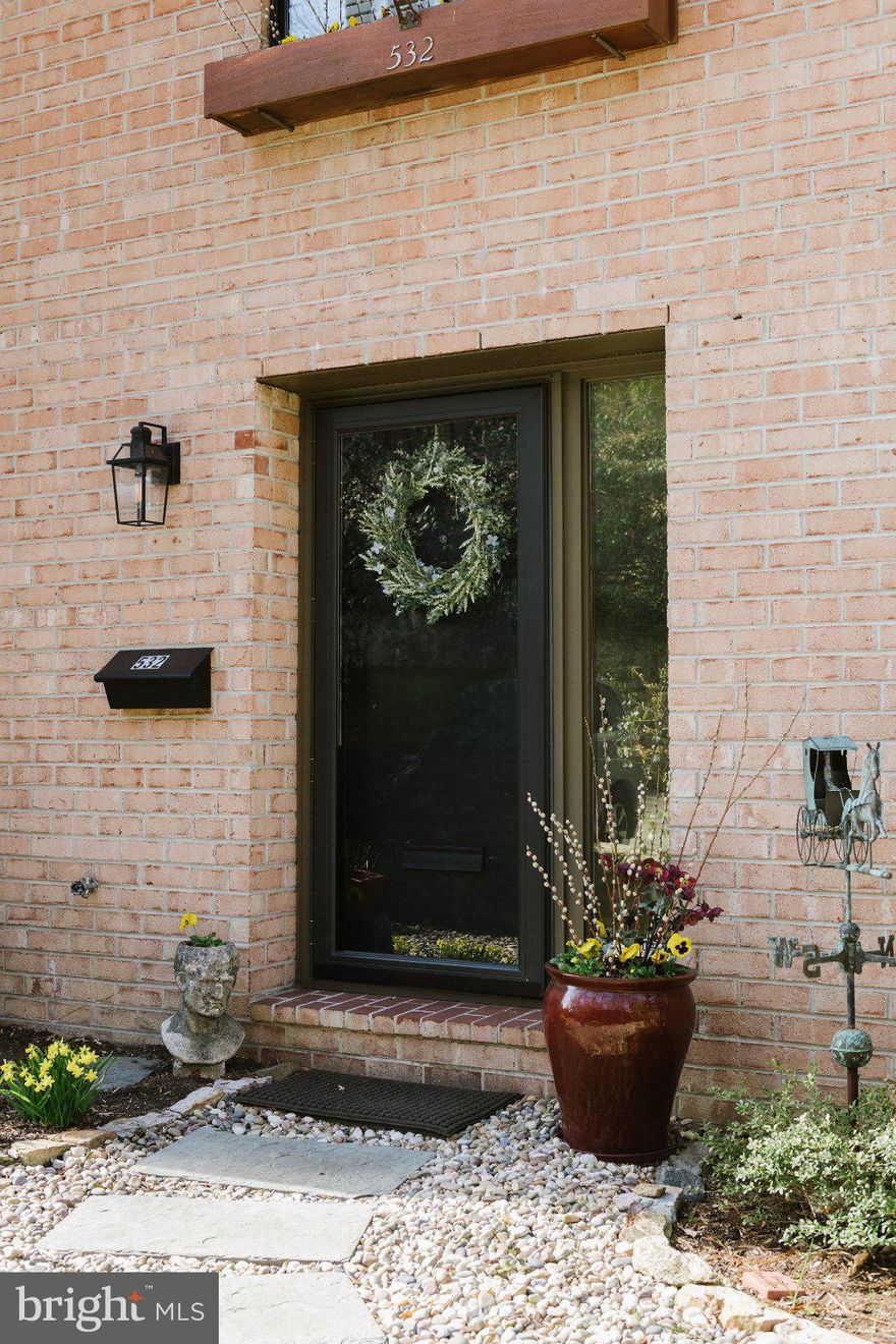 Welcome to 532 N Lemon Street, a hidden gem offering a wooded, private setting just a short walk to everything Media has to offer. This rarely available end-unit townhome, with 3 bedrooms and 2 full and 2 half baths, is tucked within the desirable Hickory Valley community, presenting a unique combination of natural surroundings, distinctive architectural design, and everyday convenience. The exterior is defined by mature landscaping with slate paver accents and peaceful creek views. As a solid brick end unit, the home benefits from additional windows introducing abundant natural light throughout the interior. A well-appointed foyer sets the tone with wainscoting, enhanced trim details, and a practical entry closet, complemented by a spacious powder room. The galley kitchen is both efficient and inviting, featuring neutral painted cabinetry, black granite countertops, a tin backsplash, upgraded hardware, and stainless steel appliances. The interior is organized around a dramatic living room with a fireplace and nearly 12-foot ceilings, a feature rarely available within the community. Overlooking this space, a generously sized dining area is positioned in a lofted setting, enhanced by natural light and complemented by an additional pantry closet for added functionality. Both the living room and the lower-level family room/den are outfitted with extra-large sliding glass doors opening to private decks maintained by the HOA. The family room/den is further enhanced by custom cabinetry and an additional closet, offering exceptional built-in storage. The upper level includes a generously sized landing with built-in shelving and a large hall closet. The primary suite is positioned to capture treetop views and includes dual closets with built-in organizers and pullouts, along with integrated window storage. An en-suite bathroom features ceramic tile flooring, wainscoting, shiplap detailing, and a frameless glass shower enclosure. Two additional bedrooms provide flexibility, including a private ensuite featuring three closets, one a walk-in, well-suited for guest accommodations. The third bedroom offers dual closets, with one serving as a utility space, along with access to a separate storage room. Just outside this bedroom, a combination laundry room and powder room add further convenience to the layout. Interior finishes have been thoughtfully updated to reflect a clean, cohesive aesthetic. Engineered hardwood flooring extends through most of the home, while carpet is reserved for the primary suite and staircases. Fresh paint, updated hardware, new lighting, blinds or curtains on all windows, and modern fixtures contribute to the home’s move-in-ready condition. Storage has been carefully considered throughout, with multiple closets, built-ins, and custom solutions integrated across each level. Two dedicated parking spaces are located directly in front of the property, with additional guest parking nearby. The homeowners association provides a low-maintenance lifestyle by managing exterior maintenance, roofing, decks, landscaping, snow removal, trash, recycling, and overall community upkeep. Set within a quiet enclave and offering walkable access to the shops, dining, and amenities of downtown Media, this home presents a rare opportunity to own a distinctive and updated end-unit townhome in one of the area’s most desirable communities. Welcome Home.