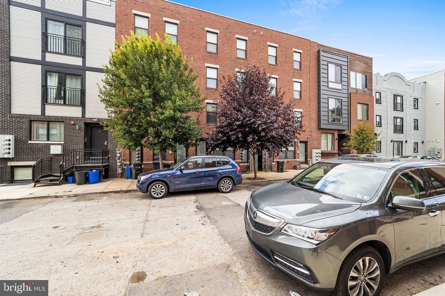 Step into the highly desirable neighborhood of Northern Liberties and claim this modern, lower-level unit as your own. Located at 970 N Marshall St, this contemporary home offers a secured entry, shared breezeway, and abundant street parking for your convenience. Upon entering, you’re greeted by an open-concept living space with engineered hardwood floors and ample natural light. The spacious living room seamlessly flows into the sleek, modern kitchen, featuring white shaker cabinets and gleaming countertops. This inviting space is perfect for entertaining guests. Off the kitchen, you’ll find a full bathroom and a versatile bedroom at the back of the home, currently set up as an office. This room boasts ample closet space and direct access to your own private patio, creating an outdoor oasis for relaxation.
Heading downstairs, you’ll discover even more updates throughout. The lower level features a large bedroom, a full bathroom, and a convenient hallway closet with a stackable LG laundry unit. The highlight of this floor is the stunning primary suite, complete with an elegant ensuite bathroom that includes a tile shower, dual vanities, and a custom closet system designed to impress.

Don’t miss the chance to make this meticulously maintained, move-in-ready home yours, with time still remaining on the tax abatement. The vibrant city of Philadelphia is calling—come make this sought-after Northern Liberties location your new home!