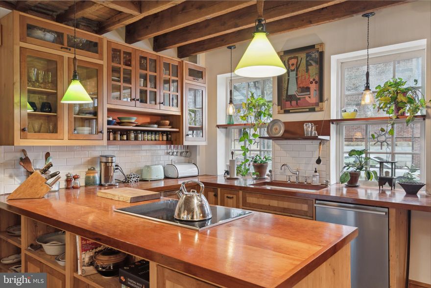 Perched on a leafy corner of Fitler Square, this enchanting townhome blends rustic elegance with artisanal allure! Welcome to 332 S 24th, a one-of-a-kind jewel box of custom details and bohemian charm beautifully woven with a symphony of repurposed wood elements celebrating craftsmanship and sustainability.

Upon stepping inside, original hardwood flooring and re-milled long-leaf yellow pine ceiling beams throughout the main level extend a warm welcome. The top of the line chef’s kitchen is fitted with beautiful custom reclaimed cherry wood cabinetry and countertops.  Modern appliances effortlessly harmonize with these handsome features, while generously sized windows overlooking Fitler Square provide ample natural light and an inviting ambiance that transcends eras. The open-plan living area is spacious yet cozy and centers on a large wood burning fireplace making it the perfect place to entertain or curl up with a good book.

At the back of the main level, a meticulously revitalized patio garden beckons through a pair of french doors, offering an idyllic backdrop for gatherings and leisure. A trellised sitting area features a custom reclaimed wood pergola with mature wisteria plantings and a beautiful wood burning fireplace ideal for cooking and entertaining at any time of year. The additional backlot area further enhances the enchanting aura that defines this home, fostering a sense of retreat within the heart of the city. A wrought iron gate provides access to Panama Street. 

The second floor offers a spacious den with beautiful hardwood floors, custom built-ins and another wood burning fireplace with a beautiful painted tile surround. An office area is framed by a large window overlooking the backyard garden, The crowning jewel resides on the third floor – an indulgent primary suit boasting soaring vaulted ceilings and ample natural light from a set of skylights with electric shades for maximum light control set the space for a freestanding tub, tiled shower with a heated floor, and rich dark wood cabinetry. The cozy sleeping area features beautiful french doors. This opulent oasis serves as a reminder of the luxurious character that pervades every corner of this distinguished townhome. The fully finished basement offers an additional sleeping area with a full bathroom and additional storage space.

In the heart of Center City’s most intimate and charming neighborhood, the residence is located right on the park for access to the weekly farmer’s market, dining at Cotaletta or Ambrosia, coffee from nearby Rival Bros. or gourmet take-out from Bacchus Market.  Jog or bike along the river at Schuylkill Banks trail, frolic at the dog park or try your green thumb at the Community garden.  Tennis courts, baseball fields and basketball courts round out the athletic offerings.  Access to major routes, public transit, 30th Street Station, PENN, HUP, CHOP, Drexel and everything Center City and nearby Rittenhouse Square has to offer.  Bring your architect, designer and imagination to help you realize the perfect urban lifestyle at this incomparable property.