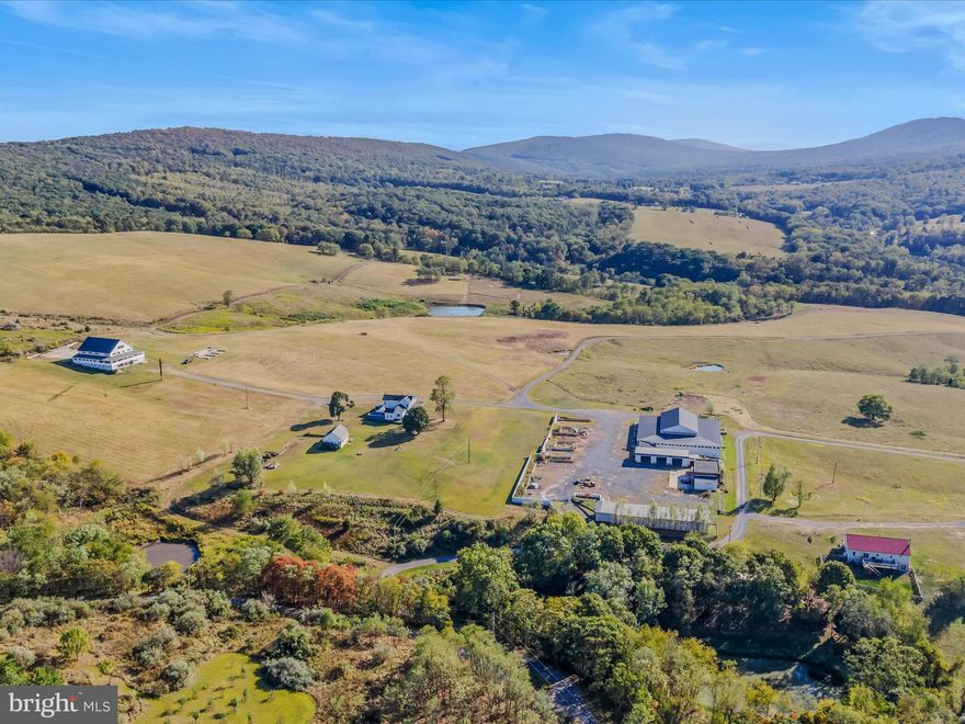 Remarkable home with 68 acres! Enjoy the breathtaking views from the property all the way around. Home features flagstone flooring, a wood stove and three bathrooms. A wrap around, covered porch makes for a great place to spend outdoors. The property features a hangar with over 7000 square feet of space and and a possible airstrip. Property features many out buildings and shops that have electric and water. There is a detached garage close to the home that features a green house also. There is storage galore on this property with the ability to expand! So many nice thought out features would make this a farm that would be ready to produce also. The outside features ponds, driveways, and fencing also. A remarkable place to call home and make memories. Possible owner financing available. Possible lease back on some of the extra buildings.