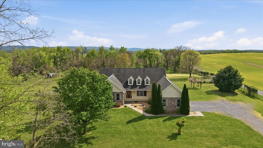 A rare opportunity to own a custom built 4-bedroom home in Charles Town, WV with over 2500 sq ft of one-level living, set on 10.88 unrestricted acres with sweeping Shenandoah Valley views, beautiful sunrises and sunsets, and space to live the lifestyle you have been looking for.

From the moment you arrive, the welcoming covered front porch invites you to slow down and take in the peaceful surroundings. Step inside to a bright foyer where vaulted ceilings and natural light immediately set the tone for the open, airy design carried throughout the home.

The heart of the home is the spacious family room, featuring a propane fireplace with stone surround, flowing seamlessly into the eat-in kitchen with stainless steel appliances, custom tile backsplash, island, pantry, and dining area. A formal dining room offers additional space for gatherings and special occasions.

Designed for everyday comfort, this one-level layout includes a flexible home office or bonus room and a private primary suite with vaulted ceilings, walk-in closet, and en suite bath with dual sinks, soaking tub, and walk-in shower. The primary bedroom also features its own propane fireplace, creating a warm and relaxing retreat. Three additional bedrooms share a full hall bath, and a laundry room with wash sink adds convenience.

Outside, the property truly shines. The lush, open acreage is ideal for animals, recreation, or simply enjoying the outdoors, all backed by trees for added privacy. Take in expansive mountain views along with stunning sunrises and sunsets that make this setting unforgettable.

A 3-car side entry garage provides ample parking and storage, while the unfinished basement offers excellent potential for future living space, workshop, or storage. A unique opportunity to enjoy unrestricted land, scenic beauty, and flexible one-level living just minutes from Charles Town.