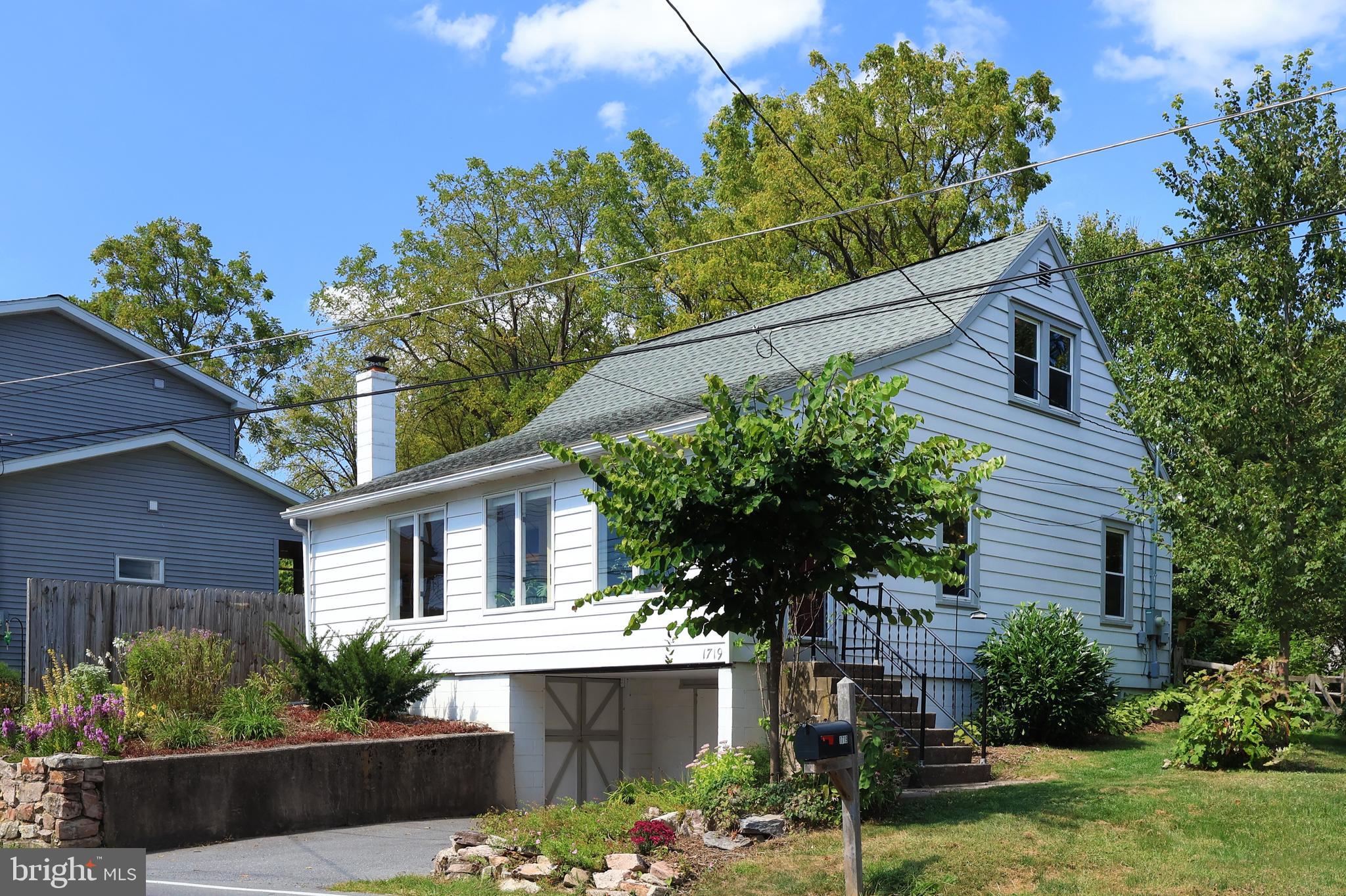 Charming Houserville cape cod oozes with character and good vibes! This wonderfully maintained and updated 1.5 story home boasts plentiful sunlight and wood flooring, custom built-ins, and lovely outdoor spaces. Enter into a foyer featuring a tiled floor and built-in bench area with a glass door that opens to the sundrenched Florida room complete with built-in bookshelves. The large living room / dining room combo boasts hardwood flooring, nice lighting, and one of the mini-split heat pumps, while the nearby kitchen features updated Kraftmade cabinetry, ample recessed lighting, maple butcher block and quartz countertops, stainless steel appliances, a tiled backsplash, and a built-in corner nook area. The convenient main floor bedroom is at the back of the home offering privacy and is adjacent to the remodeled full bath with tiled shower/tub combo and heated tile floor. Upstairs you'll find two spacious bedrooms complete with wood flooring, mini-splits, and ceiling fans, plus some built-ins in the hallway. The lower level office/hobby space with cork flooring a shelving provides a quiet spot to work and the laundry/half bath combo is adjacent to it. A one car garage and workshop/mechanical/rec space with a utility sink complete the basement level. Outside you'll appreciate the private yard featuring beautiful landscaping, pretty flowers, berry bushes, an apple tree and a garden. You'll enjoy relaxing or entertaining on the back deck and the flagstone patio complete with a pizza oven in your backyard oasis! Other features include a heat pump water heater, radon mitigation, updated 200 amp electrical panel, Pex plumbing, and added insulation. A short distance to Spring Creek Park, Millbrook Marsh, the bike path, Spring Creek Elementary, and Spring Creek Canyon, plus walking distance to Beaver Stadium and minutes to the hospital, Penn State's campus, downtown State College, and the mall area make for a terrific tucked away spot that's close to everything!