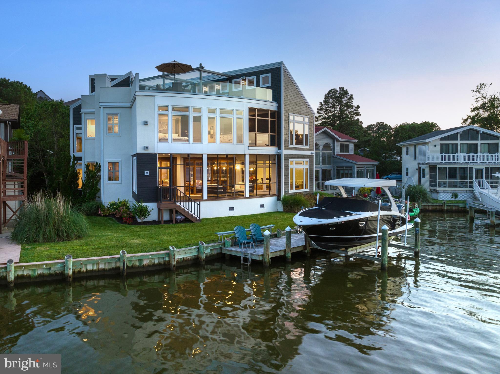 This absolutely drop dead gorgeous architectural masterpiece sits directly on the St Martins River giving way to sweeping views Eastward towards the Bay and Ocean City Skyline. Custom built in 2010 this 4 bedroom 3 1/2 bath home offers Luxury Appointments and Features that will please the most discerning Buyer. From moment you enter the grand entry your breath will be taken away with the spectacular water views as well as the unparalleled design features of this magnificent home. The Main Level features a large living area with an inviting gas fireplace and custom retractable Big Screen TV opening into a gourmet kitchen and dining area. Top End Appliances, Custom Cabinetry, Beautiful Tops and Backsplashes ice the cake ! A Large screened in Waterfront Porch/Living Area traverses the house and features a NaNa Wall System. The main level is complete with an Office Area/Wet Bar/Butlers Pantry/Half Bath and Sauna. This 3 story home includes an Elevator for everyone's convenience ! The Second Floor has an inviting sitting area at the landing, A Full Size Laundry Room with Utility Sink, 2 Large Guest Rooms with a Jack n Jill Bath with Pocket Doors. As you go down the Gallery Hallway towards the East Facing end of the house you are greeted with a wonderful private screened porch for those intimate sunrises. To the Left and to the Right are 2 magnificent direct waterfront Primary Suites with walk in closets and exquisite custom bathrooms with huge walk in showers featuring body jets etc. The 3rd Floor has an interior Landing and storage room. As you walk out onto the rooftop Shangri-La You and Your Guests will be entertained in first class style with 2 large sitting areas with retractable awnings, a Bar, Hot Tub, Sunning Deck Area with Glass Panels on the front offering unobstructed views of the water and OC Skyline. Outside, a wonderful front yard flows straight out to your Dock and 15K Lift all uniquely protected by a natural barrier island of grass. A huge storage room is accessible from outside or inside the house for water toys etc. Wonderful enclosed Outdoor Shower is perfect for cleaning up after a day on the water. This home has so many custom features and benefits that a list will be provided to potential buyers. 2 Geothermal Units, Natural Gas etc. This 4565 Sq Ft Home is a Must See Property if you are looking for the Best of the Best !!