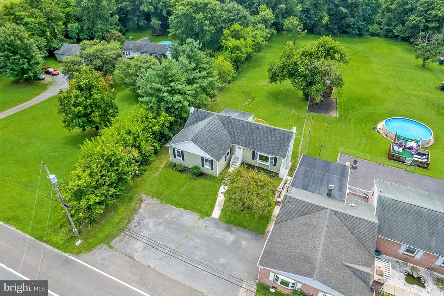 Welcome to 15827 National Pike, a home where charm meets modern comfort on a spacious 0.58-acre lot in the heart of Hagerstown—located in an area eligible for USDA 100% financing! This 4-bedroom, 2-bathroom home blends rustic warmth with thoughtful updates, starting with a living room that features vaulted ceilings, exposed wood beams, and rich wood flooring that instantly makes you feel at home. The newly renovated kitchen is filled with natural light thanks to a skylight above and features granite countertops and stainless steel appliances, with a cozy breakfast nook perfect for morning coffee. Just off the kitchen is a flexible room that can easily serve as a home office, guest room, or 4th bedroom, formal dining area, or extra sitting space. Step outside onto the brand-new deck and take in the view of your large, flat backyard—ideal for weekend barbecues, a game of catch, or quiet evenings under the stars. The lower level adds even more space for entertaining or creating the ultimate rec room, complete with a full bathroom and additional storage. With recent upgrades like a new A/C unit, septic tank, water filtration system, LVP flooring, and a 4-car parking pad out front, this home is move-in ready! Don’t miss your chance to enjoy peaceful living with the added bonus of 100% USDA financing availability!