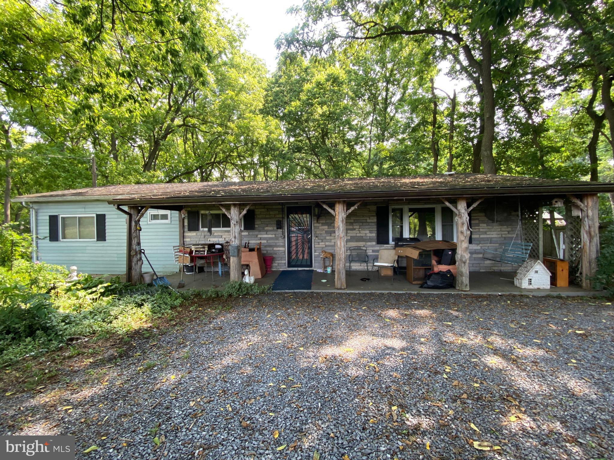 MULTIPLE OFFERS RECEIVED. HIGHEST AND BEST OFFERS DUE BY 3PM on 8/13. This property includes a large double wide on a permanent foundation with a log addition on the rear and a Guest house in the back yard. The mobile home has a large living room with hard surface floors and two bow windows. The back of the house has a kitchen with a double oven, a free-standing range, dishwasher and refrigerator, and a large eat in space in the dining room. Off to the left you will find a full hall bath, a bedroom and the primary bedroom with attached primary bath. The third potential bedroom/den is over to the right through the kitchen area. There is an amazing log cabin addition on the rear of the house spanning 21.3 x 11.6. There is an antique cooker hooked up to the chimney that is negotiable. The guest house in the backyard is an open concept studio apartment space coming in at 21.11 x 17.11. It is an open concept studio with room for a bed and a section for a kitchenette. There is also a small storage area and a bathroom in the rear. Renovate each structure and rent them both out or renovate both structures and live in the guest house while renting out the main house.
This is an estate sale, and the family members have shared what they know about the property. All measurements and housing details provided as informational and estimates.
The private drive up to the house is .34 acres and the house sits on a second lot at .74 acres. So this property is priced to sell for the condition it is in. Minutes from Shepherdstown with over 2200 sq feet, 4 total bedrooms and an acre of land...let your imagination go wild. This property is being sold CASH ONLY
Property is being sold in "as is" condition