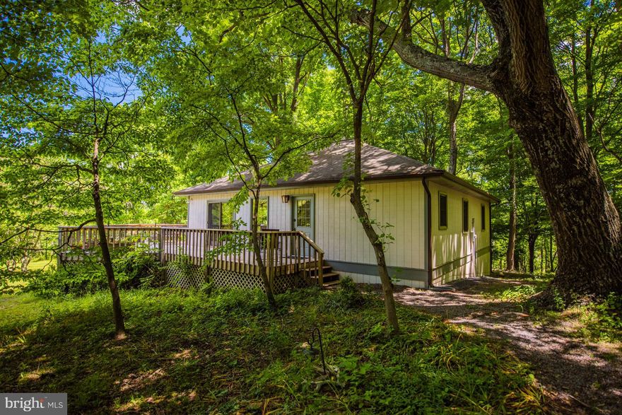 4BR/3BA home on two lots consisting of 8.6 acres of mature hardwoods approx 6 miles South of Berkeley Springs & close to The Cacapon State Park with a beautiful view of the Cacapon Mountain. Large deck,skylight, custom oak flooring & tongue groove pine ceiling. Home has lots of storage space with additional storage in craw.  Separate finished 384 sq. ft. studio/office with full bath and basement.
