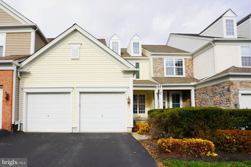 Welcome to this spacious Chester Springs carriage home in the highly sought-after Windsor Ridge community, served by the award-winning Downingtown East Schools and STEM Academy. Perfectly positioned on a premium lot backing to open space, this immaculate residence is just a short walk to the clubhouse, fitness center, pool, playground, tennis and basketball courts, and walking trails. A charming covered front porch leads into a bright entry with hardwood floors and sweeping views of the main level, where a private office with French doors, elegant living and dining areas with decorative columns and crown molding, and a sun-filled family room with marble gas fireplace create an inviting atmosphere. The open kitchen offers abundant cabinetry, expansive countertops, a large island with seating, upgraded appliances, gas cooking, and pantry, while the adjoining breakfast room opens to a spacious composite deck ideal for entertaining. Upstairs, the owner’s suite features a tray ceiling, triple windows overlooking open space, walk-in closet, and spa-like bath with soaking tub, ceramic tile shower, and dual vanity, complemented by two additional bedrooms, a hall bath, and a convenient second-floor laundry. The lower level with 9-foot ceilings, bath rough-in, and egress window provides excellent potential for future living space. Recent updates include a newer roof, hot water heater, fresh paint, professional carpet cleaning, exterior power washing, and serviced HVAC systems. With easy access to major routes, Marsh Creek State Park, Henrietta Hankin Library, shopping, and dining, Windsor Ridge offers maintenance-free living in a fantastic Chester Springs location.