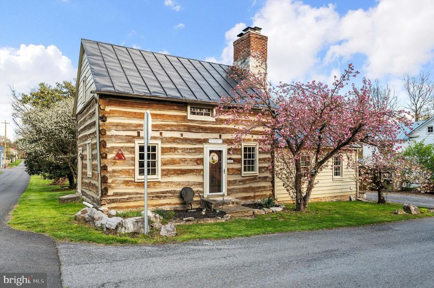Historic 1804 Log Home in the Heart of Middleway

Step into a piece of West Virginia history with this beautifully preserved and thoughtfully updated 2-bedroom, 2-bath log home in the historic village of Middleway. Built in 1804, this spacious home blends early American craftsmanship with modern comfort—and was proudly featured on the 16th Annual Homes and Garden Tour.

Inside, the charm is undeniable. The living room showcases original exposed log walls, wide-plank flooring, and one of three working fireplaces throughout the home. The updated eat-in kitchen is a standout, featuring a butcherblock counters, a wood-burning fireplace, imported Italian stove, and custom tile backsplash. A large family room with wood stove adds even more versatile living space.

The main-level primary suite offers privacy and comfort with a wall of closets and a beautifully renovated en-suite bath with radiant heated tile floors. Like the rest of the home, the bedroom is warmed by classic boiler heat, preserving its historic charm. Upstairs, the second bedroom features gable windows, plenty of  space to relax, and another wood-burning fireplace.  The second main floor full bath also has radiant tile floors.

Outside, the property is packed with character and function: a flagstone patio, stock tank pool, greenhouse, shed, fire pit, herb garden, three-bay wood shed, and fenced garden space ready for your vision.

Located in the storybook setting of Middleway—with its walkable historic district and centuries-old architecture—this home offers a peaceful lifestyle with an easy commute to Winchester, Leesburg, and Northern Virginia.

If you’re looking for something truly special—steeped in character and updated for today—98 King Street is ready to welcome you home.