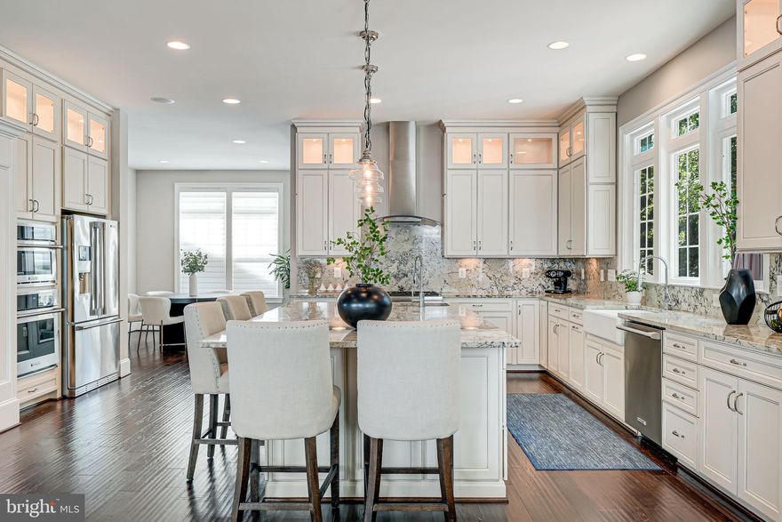 PRICE IMPROVEMENT on a beautifully outfitted Craftsman home feeding into the McLean School matrix!  Welcome to 6513 Manor Ridge Court, a stunning residence nestled in the exclusive Manor Ridge enclave—an intimate double cul-de-sac community built by Stanley Martin in 2016. This exceptional home offers over 6,600 square feet of luxurious living space across four finished levels, featuring 10’ ceilings, finely crafted moldings, and rich hardwood flooring throughout the main and upper levels. Thoughtfully designed for refined entertaining and everyday comfort, the open-concept main floor boasts a showstopping chef’s kitchen with creamy granite countertops, professional-grade stainless appliances, a porcelain farmhouse sink, and a large island with seating for five. Adjacent formal and casual spaces—including a coffered-ceiling living room with gas fireplace, sunlit breakfast area, and gracious dining and living rooms—blend timeless elegance with modern ease.

Step outside to your private backyard sanctuary, where luxury and serenity await. A fully screened-in porch, complete with a wall-mounted TV, ceiling fan, privacy curtains, and built-in speakers, opens seamlessly onto a sun-drenched Trex-style deck overlooking manicured greens—ideal for al fresco dining or lounging around a fire pit. Below, a beautifully hardscaped patio features an indulgent hot tub, rustic stone accents, paneled ceilings, ceiling fans, ambient lighting, and dual seating areas, making it a year-round retreat. An attached two-car garage with extensive custom storage, plus a handsome brick driveway with room for two additional vehicles, ensures both style and practicality.

Upstairs, the opulent primary suite offers a rare level of comfort, with dual walk-in closets (including one with a center island), a private sitting room, and a spa-inspired bath with a soaking tub, granite-topped vanities, and a rainfall shower. Each of the three additional upper-level bedrooms includes its own walk-in closet and en-suite bath, while the finished lower level features a professional-grade home theater, gym area, fifth bedroom and bath, office nook, and expansive recreation space. Perfectly situated near top-tier schools, world-class dining, shopping, and two Metro stations, this exquisite home is a rare offering that balances refined living with everyday convenience in the heart of McLean.