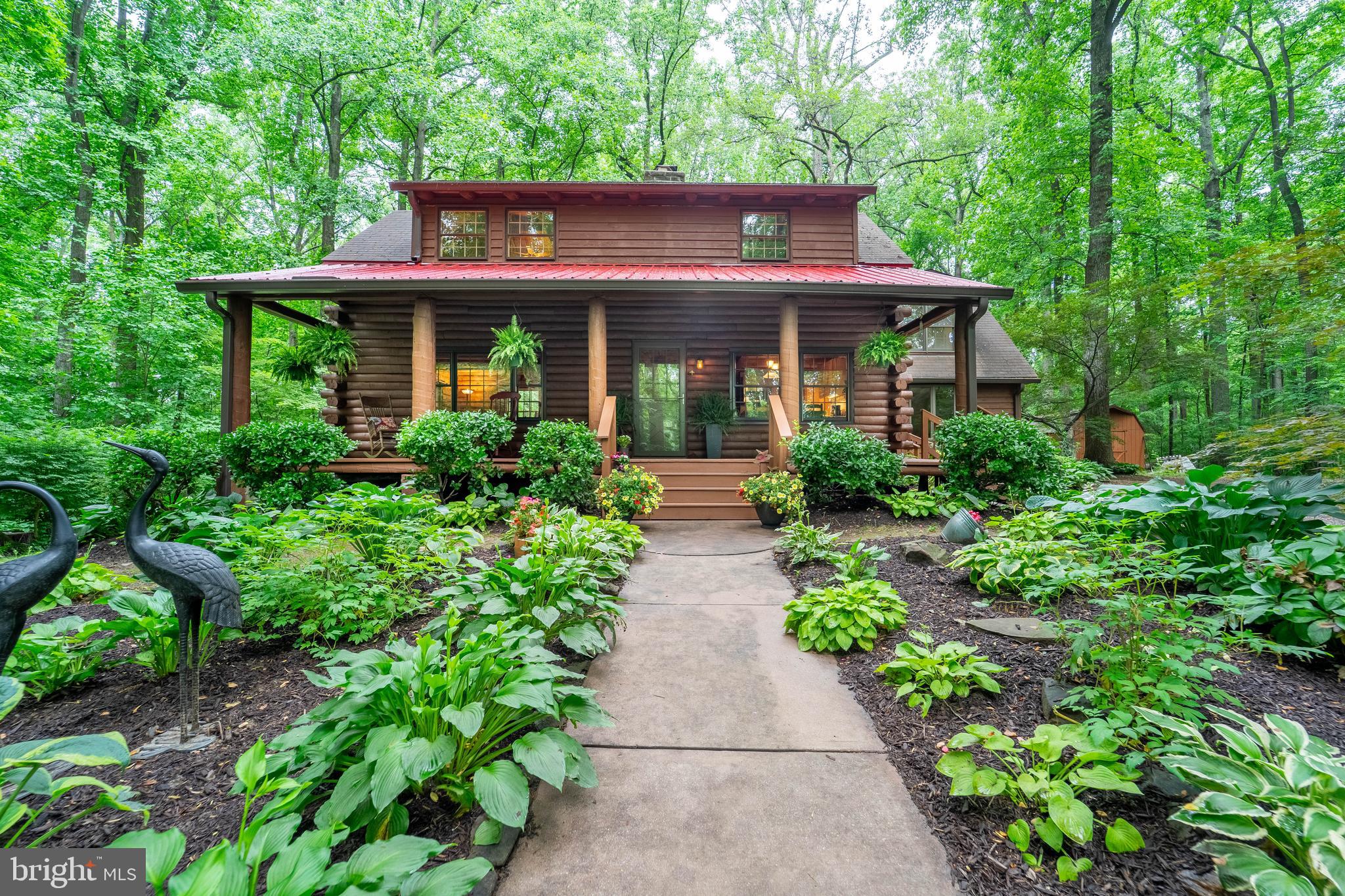 Nestled on a serene and private one-acre lot, this beautifully crafted custom log cabin offers the perfect blend of rustic charm and modern comfort. A picturesque front walkway leads to the oversized porch, where peaceful views create a warm and welcoming first impression.
Step inside to discover stunning, antique original Georgia Pine wide plank floors that add warmth and character throughout the home. The interior showcases authentic log walls, adding timeless appeal to every room.
On the main level, the inviting living and dining area features a striking two-sided stone accent wall, setting the tone for the home’s rustic elegance. The updated kitchen boasts granite countertops, stainless steel appliances, a spacious island ideal for gatherings, and abundant cabinet space. A freestanding wood-burning fireplace backed by a dramatic stone wall completes the cozy atmosphere.
Just beyond, a spacious and versatile room offers the flexibility to serve as a main-level bedroom or generous family room, with sliding doors opening to a rear deck and stair access to the private, lush backyard.
The main floor also includes a full bath with a classic clawfoot soaking tub, perfect for unwinding, a private office or second bedroom, and a convenient laundry room with built-in closet and shelving.
Upstairs, the primary suite offers an updated full bath and a private sitting area, creating a serene retreat. Two additional bedrooms with striking vaulted ceilings complete the upper level.
The fully finished basement expands your living space with a large family room featuring chair rail detail, a dedicated exercise room, recessed lighting throughout, and walkout access to the backyard. A full bathroom has been added for convenience and comfort, and the basement offers an easy opportunity for conversion into a complete in-law suite.
Outside, a generous storage barn sits just steps from the home—ideal for tools, equipment, or hobbies. A new roof (2 years old) and new lower-level windows add peace of mind. This one-of-a-kind log cabin delivers the ideal combination of charm, practicality, and seclusion.