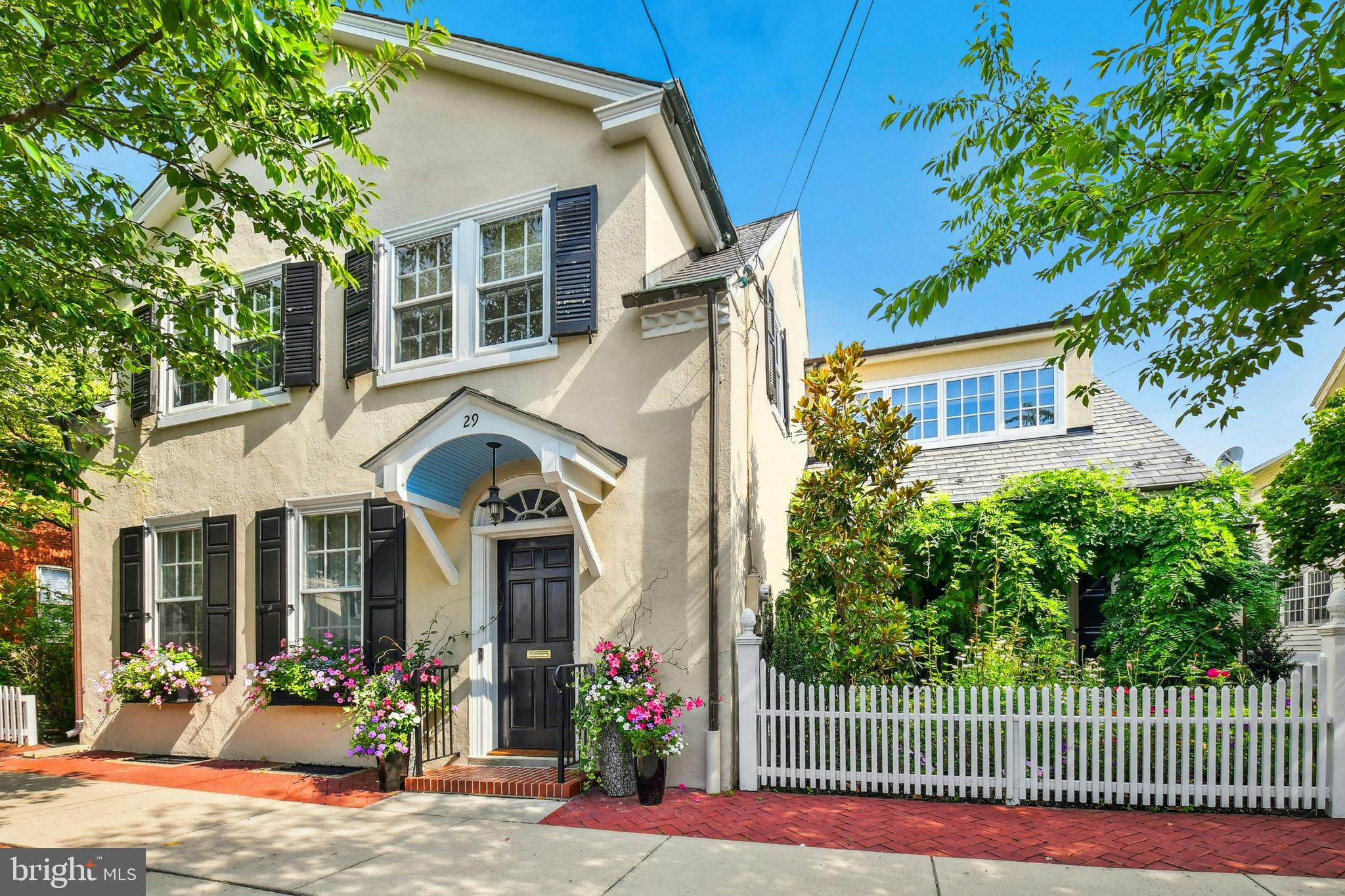 This fully renovated historic home is a quick stroll away from Main Street, Bethlehem, recently named the “Best Main Street in the Country” for 2025 and designated a Unesco World Heritage Site. The vibrant neighborhood offers culture, history, and diverse dining surrounding this charming turn of the century gem of a home.
Befitting the enviable location, the property has been renovated and enhanced with timeless and luxurious appointments. The elegant living/dining room is grandly proportioned yet intimate, with a marble fireplace, built-in cabinetry and detailed moldings. The heart of the home is a breathtaking newly renovated kitchen with extra thick Carrera Gold Marble counters, La Cornue French range, vaulted ceiling, heated floors, and French doors to the expansive rear yard. A convenient first floor primary suite is a welcome surprise, boasting a soaring tray ceiling, dual bathrooms with heated floors, walk-in closets, and access to a private covered outdoor living room with Mercer fireplace and romantic sunken spa. A cozy den with a wall of built-ins opens to a covered porch beside an enchanting flower garden complete with picket fence. The second floor houses 3 ample bedrooms and a modern bath.
One of only a handful of homes in the historic district, this property offers an extravagant rear yard with an inground pool, patios, covered outdoor living room, and professionally designed manicured gardens. A meandering path through the expansive back lawn leads to garaging for 3 vehicles including a fully renovated, heated 2-car garage.