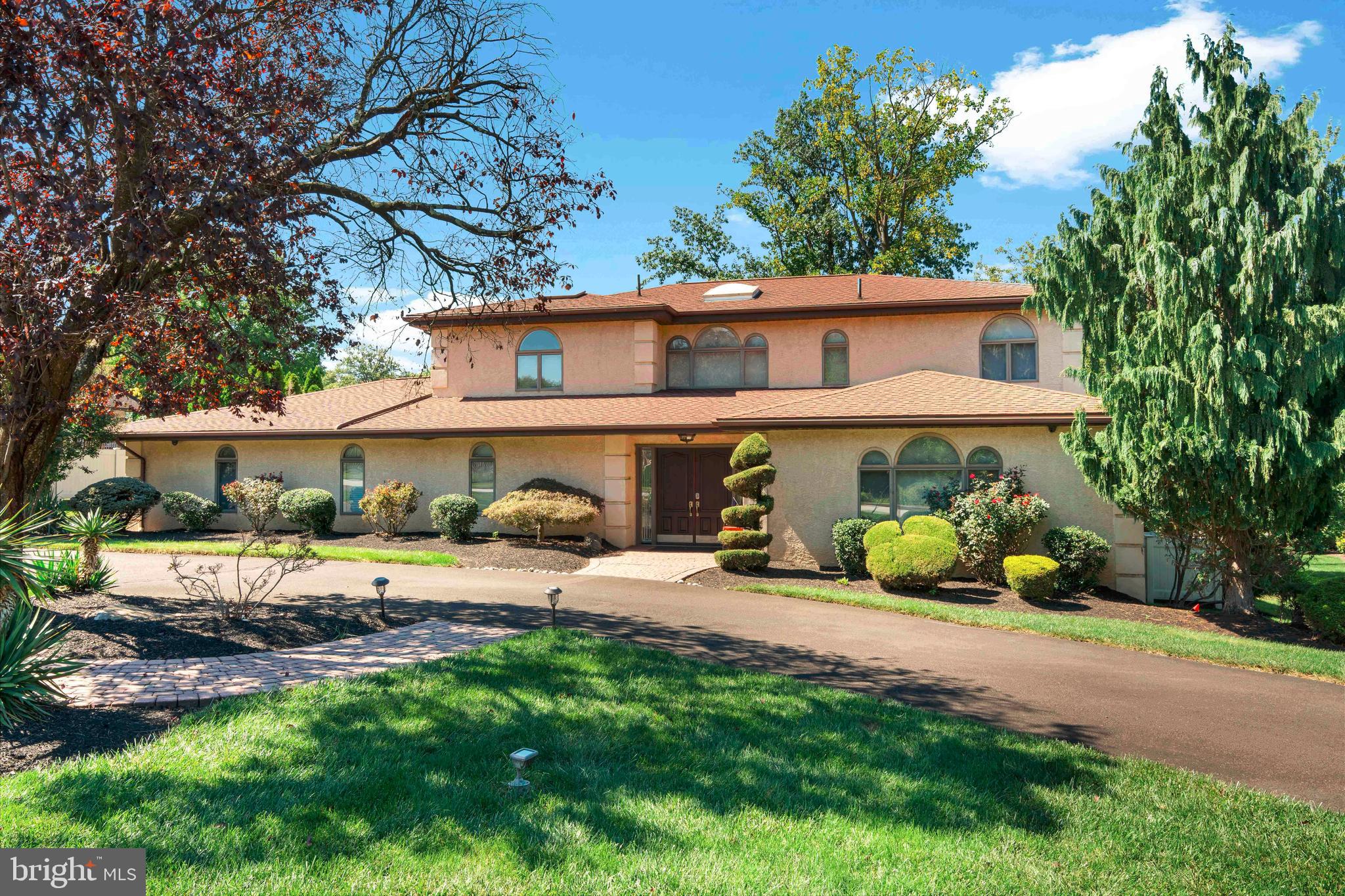 Perfectly situated in the highly sought after Justa Farms neighborhood, this expansive Colonial blends timeless design with modern amenities and an incredible outdoor oasis. With five bedrooms, four and a half bathrooms, a gorgeous in-ground pool, and a layout made for both entertaining and everyday comfort, this home truly has it all.
A stately horseshoe driveway and two car garage set the tone for the property. Step inside to a dramatic two-story foyer with tile flooring that opens into a sunken living room with a vaulted ceiling. The formal dining room is an entertainer’s dream, featuring recessed lighting, crown molding, chair rail, and tile floors for a touch of elegance.
The heart of the home is the eat-in kitchen, boasting a spacious island, Sub-Zero refrigerator, wall oven, electric cooking, and sliding doors leading to a two-tiered deck. Just off the kitchen, the sunken family room creates a warm and inviting space with its custom stone fireplace, built-ins, and sliding doors opening to the lower deck and pool area. A powder room, large office with recessed lighting, and a laundry room with cabinets, tile floors, and utility sink add convenience. From here, a hallway connects to the two car garage with an additional storage room.
Upstairs, you’ll find two generously sized bedrooms connected by a Jack and Jill bathroom with a double vanity and stall shower. A third bedroom is currently styled as a custom walk-in closet with center island but can easily be converted back. A separate hall bath with tile floors, double sinks, and a stall shower provides additional space.
The primary suite is a private retreat featuring built-ins for abundant storage, a private balcony, and a spa-like en suite with oversized double vanity, Jacuzzi tub, separate stall shower, and a skylight that fills the space with natural light.
The finished lower level offers incredible flexibility with two additional bedrooms, a full bath, a kitchenette room, a large recreation space, and a dedicated gym room, perfect for multi-generational living, a guest suite, or simply spreading out.
Outdoors, the fenced-in backyard is an entertainer’s paradise. A two-tier wooden deck overlooks the sparkling in-ground pool, offering the perfect backdrop for summer gatherings and relaxing weekends at home.
This exceptional property in Lower Moreland’s award-winning school district delivers space, style, and a lifestyle that is second to none.