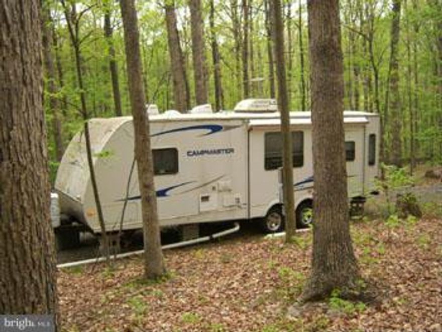 2.33 Acres with Cacapon River Access!  Well, Septic , Electric and Driveway already installed, 2010 28 ft Camper trailer conveys , This ones ready to enjoy this summer. Just think - camping, fishing, lazy evenings around the camp fire, Don't wait too long and be sure to bring that fishing pole. Extra lot also available.