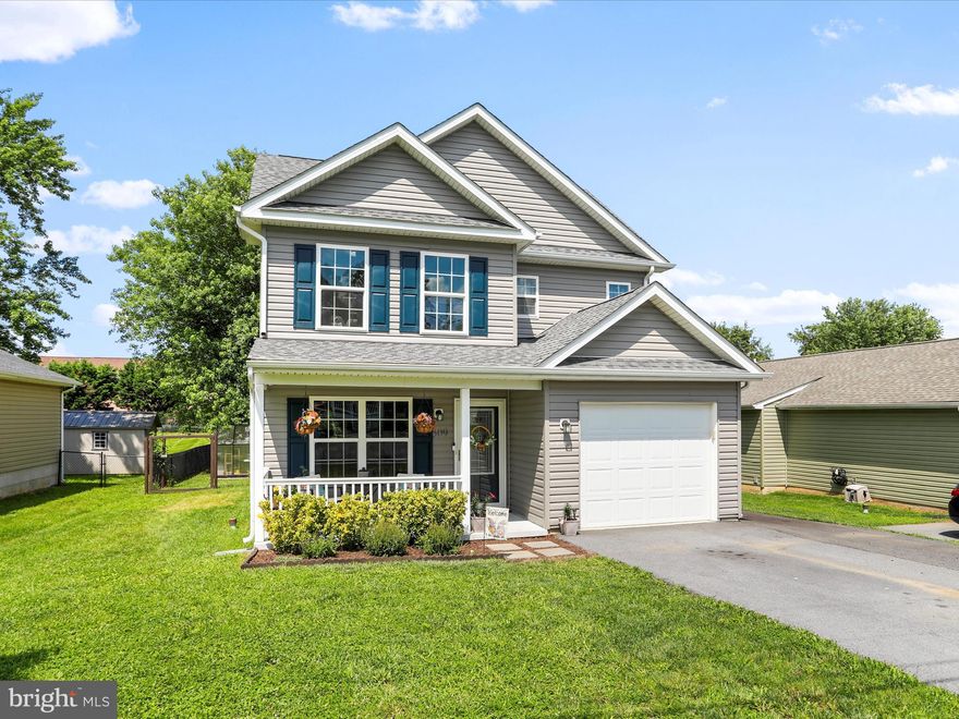 Welcome to this meticulously maintained Colonial-style home, perfectly located in the heart of Martinsburg. Only 5 years old, this 3-bedroom, 2.5-bathroom charmer offers 1,270 sq ft of thoughtfully designed living space with modern features and classic charm. There are many cool nuances within this living space including soft LED lighting in the kitchen, The main-level primary suite includes an en-suite bathroom for added privacy and convenience, while two additional bedrooms and a full bath are located upstairs. The open-concept living and dining areas create a warm, inviting atmosphere, ideal for both everyday living and entertaining. The kitchen is outfitted with stainless steel appliances, including a refrigerator, range/oven, microwave, and dishwasher. Enjoy durable laminate flooring throughout the main living spaces, a heat pump system for year-round comfort, and an attached one-car garage with extra storage space. Step outside to a fully fenced backyard featuring a cozy covered back porch and functional greenhouse for those with a green thumb. Great time and effort were placed into creating a peaceful sanctuary, complete with firepit area.  The large, flat lot (.23 ac) could easily accommodate a substantial storage shed, or trampoline, or corn hole area if you desire.  This location offers convenience as it is near local schools, parks, shopping, MARC train and major commuter routes. This home offers the best of comfort, space, and accessibility.