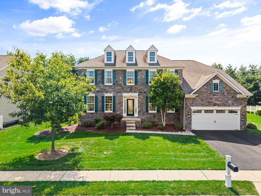 Welcome home to 1377 Gabriel Lane, a show-stopping four-bedroom colonial with an impressive stone elevation, nestled in the highly sought-after Golf Club Estates. This beautifully upgraded home boasts gleaming hardwood floors on both the first and second levels, an abundance of natural light, and four full bathrooms. The grand two-story foyer is flanked by elegant formal living and dining rooms, both enhanced with elevated crown molding and wainscoting for a truly refined aesthetic. The living room impresses with a gas fireplace with marble surround and a stunning coffered ceiling, while the kitchen serves as the heart of the home, featuring an oversized island, white custom cabinetry, granite countertops, neutral tile backsplash, and stainless steel appliances, including a gas range and double oven. A sunny dining nook with a cathedral ceiling overlooks the picturesque backyard, and just beyond, the Trex deck offers million-dollar views of adjacent farmland, framed by blooming limelight hydrangeas that provide both beauty and privacy. The main floor also includes a full bathroom, spacious mudroom with built-in cabinetry, convenient laundry room, and spacious two-car garage. Upstairs, the luxurious primary suite is a peaceful retreat with wall-to-wall windows, separate sitting area, two walk-in closets, and spa-like en suite bath complete with soaking tub, stall shower, two separate vanities, and private toilet closet. The second bedroom offers its own en suite bathroom and walk-in closet, while the third and fourth bedrooms share a stylish hallway bath with dual vanity and a tub shower. Descend to the daylight basement, fully finished with high ceilings and sliding glass doors to the backyard, as well as roughed in plumbing for an additional bathroom. Lovingly maintained by its original owner, this home radiates pride of ownership, with an affordable HOA that adds to the ease of everyday living. Assigned to award winning Central Bucks School District and conveniently located near shopping and commuter routes, this is the one you’ve been waiting for. Schedule your private showing today!