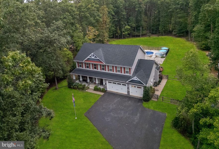 8205 Musket Ridge Lane offers a refined blend of elegance and livability in one of Spotsylvania’s most sought-after locations. Nestled just off River Road and minutes from the natural beauty of Motts Run Reservoir, the home provides the rare combination of convenience and tranquility. A soaring two-story foyer introduces the main level, opening to a formal living room with timeless moldings on one side and a versatile dining room on the other. At the center of the home, the kitchen features expansive granite countertops, abundant cabinetry, and a built-in bar that is perfect for entertaining. A cheerful breakfast nook and a sunroom wrapped in glass invite natural light and frame views of the serene grounds, while the kitchen flows seamlessly into the family room, where a warm fireplace and generous windows create an inviting gathering space. Just off the oversized three-car garage, a convenient mudroom provides the perfect transition area, keeping everyday life organized and tidy.

Upstairs, the private quarters are highlighted by the expansive primary suite, a luxurious retreat with space for a sitting area and an en suite bathroom that feels like a spa. The oversized shower with sleek, modern finishes creates a sense of calm and relaxation, elevating daily routines into moments of indulgence. Three additional bedrooms share a well-appointed full bath, and a large second-level laundry room adds to the thoughtful design — its generous size and central placement bring everyday convenience right where it’s needed most.

The finished lower level extends the home’s versatility with a spacious recreation room, bonus areas perfect for a gym, media lounge, or hobby space, and the added convenience of a full bathroom. With direct walk-out access to the backyard, this level enhances the seamless flow between indoor and outdoor living, making it ideal for entertaining guests, creating a private suite, or simply enjoying more flexible living space.

The rear of the property is where the home truly shines. A sparkling in-ground pool forms the centerpiece of a private outdoor oasis, bordered by a wide patio for lounging, dining, and entertaining. Set on more than two acres framed by mature trees, the yard balances openness with seclusion, making it ideal for both gatherings and quiet relaxation. Whoever the lucky new buyers may be, they will not only be gaining a home, but a lifestyle — one defined by elegance, comfort, and the unique charm of River Road living.