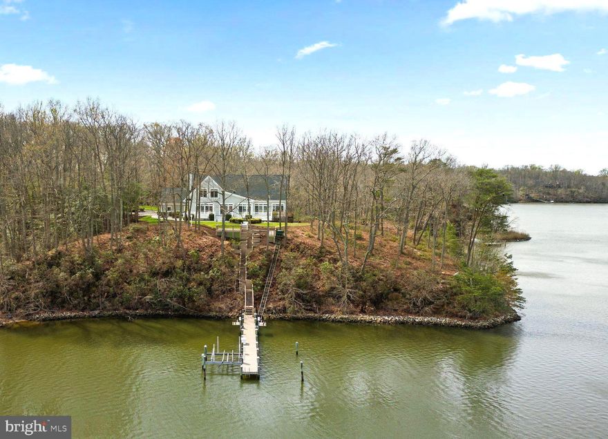 A Waterfront Sanctuary on Beards Creek. Discover an unparalleled custom-built waterfront estate, a hidden gem nestled on 5.82 private acres along serene Beards Creek just off the South River. This exceptional property offers over 600' of water frontage and breathtaking 180-degree water views, providing a truly one of a kind waterfront living experience. A private tram descends to your 100' private pier, complete with a boat lift and 8' MLW, for effortless access to the open waters. The residence features a 2-car garage and additional storage sheds, catering to the needs of boating enthusiasts and offering ample space for all water-related toys. The expansive deck offers an idyllic vantage point, perfect for taking in the panoramic views. Inside, the home is bathed in natural light, thanks to the huge walls of windows that showcase the stunning views. Gleaming hardwood floors, fresh designer neutral paint and high-end finishes are evident throughout. The open-concept main level seamlessly integrates the great room, gourmet kitchen and formal dining room, creating an ideal space for both intimate gatherings and grand entertaining. A more formal sitting room provides an additional elegant space for entertaining larger crowds. The main level also features the primary suite complete with en suite bathroom and a generously sized closet. A second bedroom with a private bathroom, a dedicated home office/study, convenient main-level laundry room, and a half bathroom complete the main living level. The upper level offers two additional, spacious bedrooms, a hall sitting room and a full designer bathroom. As a bonus, there is finished flex space – ideal as a game room, teen retreat, or a bunk room to host even more guests. The fully finished lower level offers walk-out access, and easily serves as dedicated accommodations for an in-law or au pair suite complete with a living area, private bedroom and fourth full bathroom. This is a truly remarkable property and a rare opportunity to own a significant waterfront estate, offering a lifestyle of unparalleled luxury, privacy, and natural beauty. Schedule your private tour today!