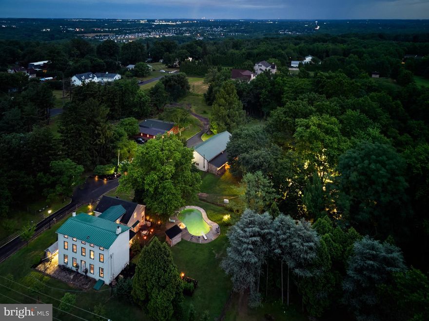 Welcome to this charming oasis set on 3+ acres of stunning Bucks County landscape! 1090 Almshouse Road is a unique property welcoming enjoyment, tranquility and convenience. The original farmhouse dating back to 1880 features inviting rooms, original pumpkin pine floors, deep windows, built-ins and beautifully blends with the newer additions that include an expansive gourmet Kitchen featuring Viking stove, Sub Zero Refrigerator, custom cabinetry and countertops and a 2-story Dining Area with gorgeous views and gas-burning Fireplace. An open staircase leads up to a large, open loft that is ideal for working from home, art studio or home gym; and 3 large bedrooms with gorgeous, wood floors and a stunning, modern Hall Bath with radiant flooring complete the 2nd floor. The enclosed rear porch and lovely deck offer spaces to enjoy throughout the seasons. Beautifully designed outdoor lighting create a magical atmosphere and invite evening relaxation and entertaining by the heated pool and spa.  In addition to the main farmhouse, the Original Bank Barn has been renovated into an incredible additional living space for entertaining and welcoming friends, family or out of town guests and features exposed stone and exposed beams, great room with Kitchen, 2 bedrooms and spa-like full bathroom. With multiple out buildings including an incredible Pole Barn divided into 2 expansive heated and air conditioned spaces (40x30 and 30x30) complete with oversized garage doors ready for a workshop, hobbyists, auto-enthusiasts and contractors. This home also features a 20kw natural gas generator that powers the main house, pool and workshop for that extra sense of security throughout the changing seasons. In addition, fenced in pastures are ready for play and pets, additional barns offer great storage, and a root cellar is waiting to store your favorite wines! Zoned RA , featuring low taxes and many uses and located just a short drive to shopping, dining, local and major routes and in award-winning Central Bucks, 1090 Almshouse Road is ready to welcome you with historic Bucks County charm, vacation vibes and modern amenities!