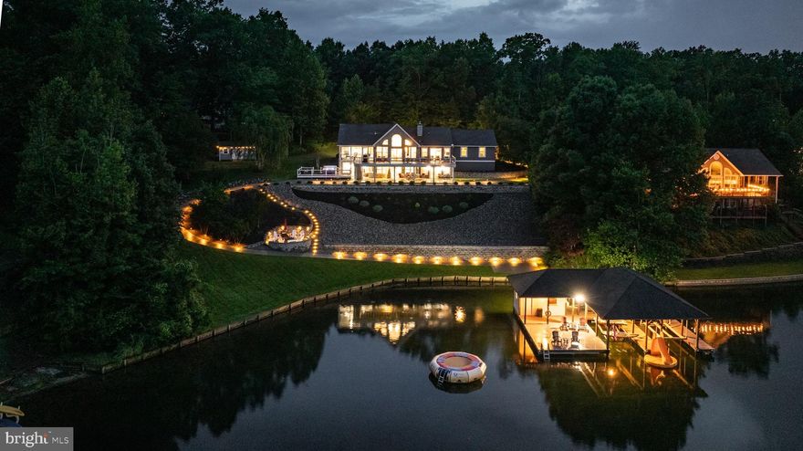 Commanding over 200 feet of waterfront shoreline on a massive 3-acre lot, this newly renovated Lake Anna compound displays miles of uninterrupted water views.  This completely furnished turn-key waterfront lake house (NON-HOA) offers 6 bedrooms, 4 bathrooms, and 4,000 square feet of private tranquility, sited on the public side of Lake Anna.  Thoughtfully designed for the lake enthusiast, nearly every room of this magnificent retreat offers stunning water views.  Outside, this property is appointed by a large two-slip boathouse with kitchenette, dining area, water slide, and 15-foot water trampoline; a deep hot tub overlooking the lake, a tremendous back deck offering panoramic views of Lake Anna, and a recently-constructed hardscaped fire pit.  Floor-to-ceiling windows in the newly-renovated great room dissolve the line between indoors and outdoors, and showcase jaw-dropping views of Lake Anna.   Anchored by a nautical shiplap fireplace and rustic wood mantle, the wide open great room features high vaulted ceilings and abundant natural light.  The state-of-the-art renovated kitchen offers beautiful new granite countertops, stainless steel appliances, a large island with second sink, gorgeous tile backsplash, and separate coffee bar.  The primary suite is on the main level, and features its own private screened-in porch with lake views, a walk-in changing room/closet, and a newly renovated spa-inspired bathroom with double vanity, and a frameless walk-in tile shower.  The main level offers two additional guest rooms, a full bathroom with tub, and laundry room.   Tailored for entertaining, the lower level is centered around a large recreation space, which includes a movie-screening area, pool table, corner wet bar, and stone-encased wood-burning fireplace and mantle.  Your guests will rave about the three additional bedrooms on the lower level (two of which have stunning water views), coupled with a new large bathroom, offering another walk-in shower, and storage closet.  If you don't want to walk to the boathouse, just hop into your golf cart (included with purchase) and follow the concrete path directly to the boathouse.   If the large attached two-car garage isn't enough space, then take advantage of the massive detached three-car garage with unfinished upstairs second level, perfect for storing boats, additional vehicles, and ATVs.   There is plenty of space for an in-ground swimming pool in the open grass area adjacent to the home and hot tub.  The owners recently installed an extravagant stone fire pit near the water's edge, surrounded by beautiful grey stone hardscaping.  The landscape and hardscape lighting at this magnificent residence are unparalleled at Lake Anna.  INVESTORS: this non-HOA waterfront enclave is absolutely ideal for short term rentals, considering the layout, size, amenities, water views, and waterfront / outdoor features.  Location could not be better: less than 5 minutes to groceries, restaurants, Cutalong Golf Course, fast food, The Lake Anna Taphouse, Coffee & Creamery, vet clinic, and more.  High speed internet.  All furnishings, furniture, and decor convey - and so does the golf cart.  List of recent renovations and upgrades in documents section.