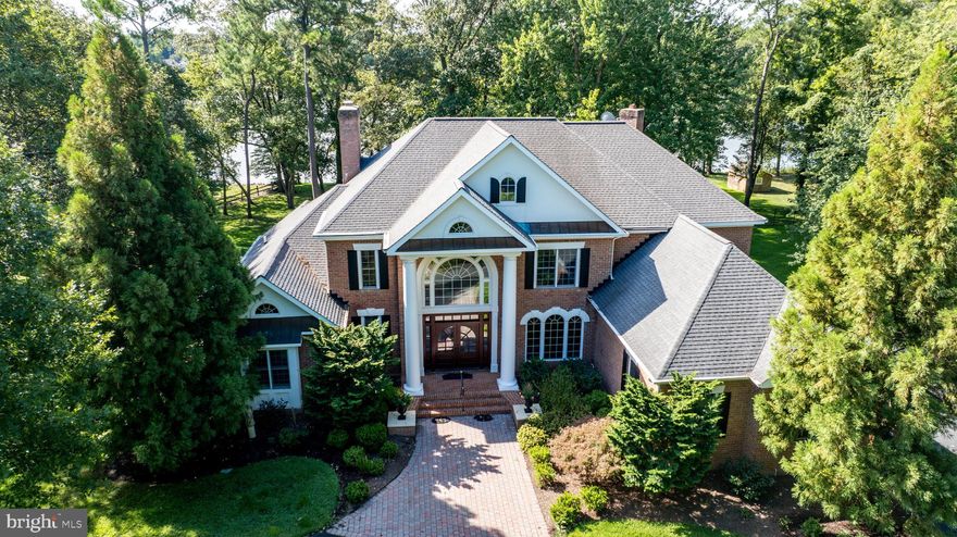 Nestled off the sought-after Oxford Road corridor, this custom-built Georgian-style home sits gracefully on 2.13+/- acres with breathtaking views of Trippe Creek. The property boasts a rip-rapped shoreline, private pier complete with two slips, a boat lift, and approximately 4 feet of MLW. The home is a masterpiece of craftsmanship, featuring exquisite millwork throughout. The expansive waterside composite deck, complete with a hot tub, offers the perfect space to unwind and soak in the serene water views. For those who love outdoor living, the screened porch provides a tranquil retreat. The family room, adorned with a gas fireplace, opens to the chef’s kitchen with high-end appliances, island, and breakfast bar, creating an ideal setting for less formal entertaining. The formal dining and living room areas exude elegance, perfect for hosting special occasions. The main level hosts the primary suite, offering stunning water views and direct access to the deck. The luxurious primary bath features double vanities, a tiled shower, and ample closet spaces, providing a spa-like experience at home. The second floor landing is a versatile space, perfect for an office or reading room, complete with built-in bookcases and sweeping water views, thanks to the 2-story formal living room. Three additional en-suite bedrooms provide comfort and privacy for family and guests. This amenity-packed home is an attached 3-car garage, a shed for additional storage, and a decorative wrought iron fence perfect for four-legged family members. This Georgian-style gem offers a perfect blend of elegance, comfort, and convenience in a premier location.