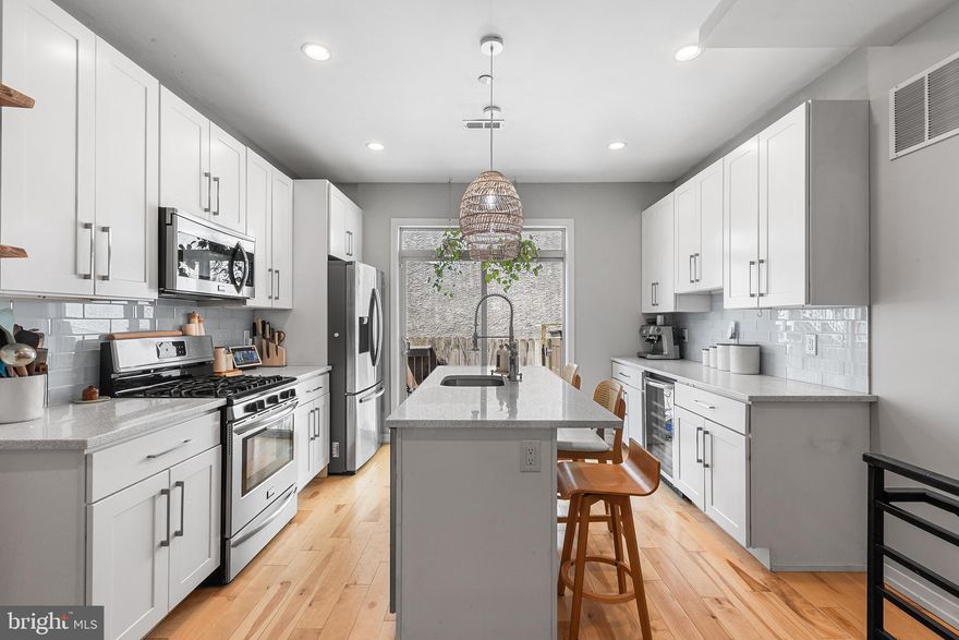 Welcome to 1204 S Bucknell Street—an exceptional newer construction residence in the heart of Point Breeze. Offering over 2,300 square feet, this 3-bedroom, 3-bath home is thoughtfully designed with soaring ceilings, abundant natural light, and three private outdoor spaces. The main level features an expansive open-concept layout ideal for both everyday living and entertaining. Rich wood flooring flows throughout, complemented by a gas fireplace and custom glass and brass floating wood shelving. The chef’s kitchen is anchored by a large center island with breakfast bar seating and wine refrigerator that seamlessly connects to a private patio—perfect for indoor-outdoor living. Upstairs, the second level offers two spacious bedrooms, a beautifully appointed hall bath, and a convenient laundry area. The top-floor primary suite serves as a true retreat - complete with a private balcony, custom walk-in closet, and a spa-inspired bath featuring dual vanities, heated towel rack and an oversized walk-in shower. A wet bar and wine refrigerator lead to the rooftop deck, showcasing sweeping Center City skyline views. The fully finished basement provides versatile living space ideal for a media room, guest suite or home office along with a full bath and additional storage. This home is outfitted with premium upgrades including integrated smart home audio, staircase lighting, dual-zone HVAC, custom window treatments and smart locks for modern convenience. A seamless blend of luxury, comfort, and urban accessibility—this is city living at its finest.