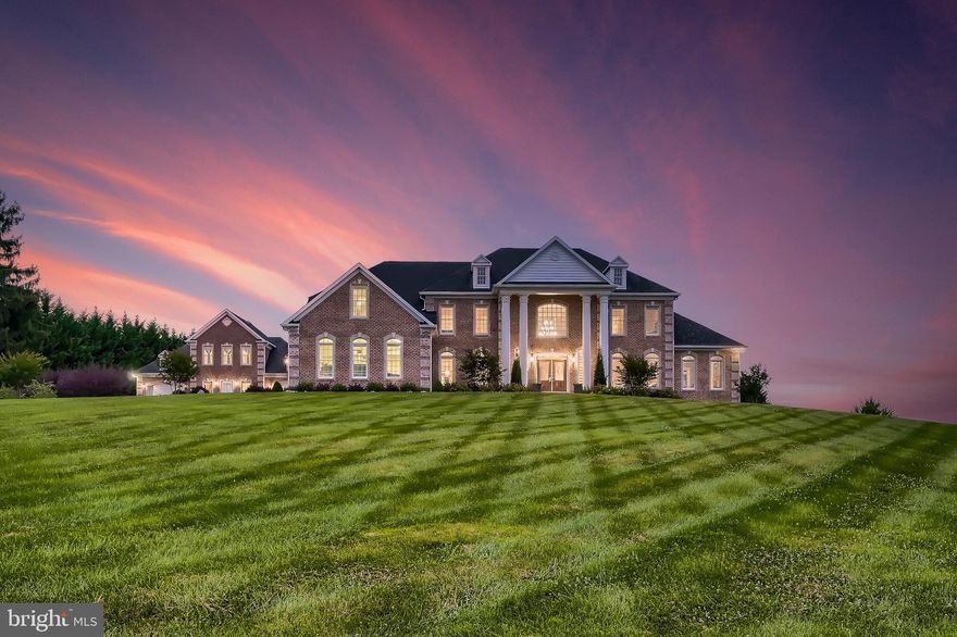 Cathedrals aspire to the heavens, monuments declare defining achievements, and corporate buildings exude success.  The only other standout is in the residential domain and it is defined by the culture of the time and the individual owner.  In 2006, the year of construction of this property, optimism reigned supreme as the economy was at a peak.  Those with the requisite means could commission and acquire the grand style and the finest materials.  This estate is a prime example of that zeitgeist.  

A retreat by location, though close to the city, sets your pace a couple of clicks back before you arrive.  The long, curved driveway leads the eye to the residence perched on the manicured knoll.  Brick exterior walls are braced by quoins, like stitching on a baseball, while stately columns lend visual brawn and elegance.   The structure is dignified and measured in a timeless fashion.  It is big and strong, like an ark built to hold two of every happiness. 

Double doors spread like welcoming arms under the covered portico.  Behind them, a marble-floored two-story foyer with a double staircase reflects the symmetry and space typical of Georgian design.  It is grand but not stifling.  It impresses but with room for laughter to echo.  Unlike estates that evolved over time, this one has the benefit of a cohesive design.  Space is ample in every area. Architectural details help define and compliment the space. Wainscotting, coffered and tray ceilings, and columns, balance the height and tone down the sound.  The open floorplan allows the abundant natural light to race across the marble, porcelain, or random-width oak planks foundation.  The kitchen is equipped to handle anything from glorious feasts to intimate nightcaps afterward.  The master bath is laid out like a personal spa to be your personal sanctuary.  Similarly, closet space is abundant, with the master walk-in closet that would qualify for an apartment in the city.  The garage space is equally prepared to house your collection or all your vehicle charging needs.  There is a place for everything and everything is of substance.  Even the guest house with its own garage (double, of course) is constructed to the same exacting high standards.  Systems include geothermal energy and wells for water.  A mindset of self-sufficiency and intelligent efficiency.

All these attributes of strength, elegance, forethought, and quality may convey what the house says about the owner’s persona, but architecture is a language, and language fosters communication.  In that sense, this property seems to be like a caring parent that provides you with the mindset needed to have agency and success.