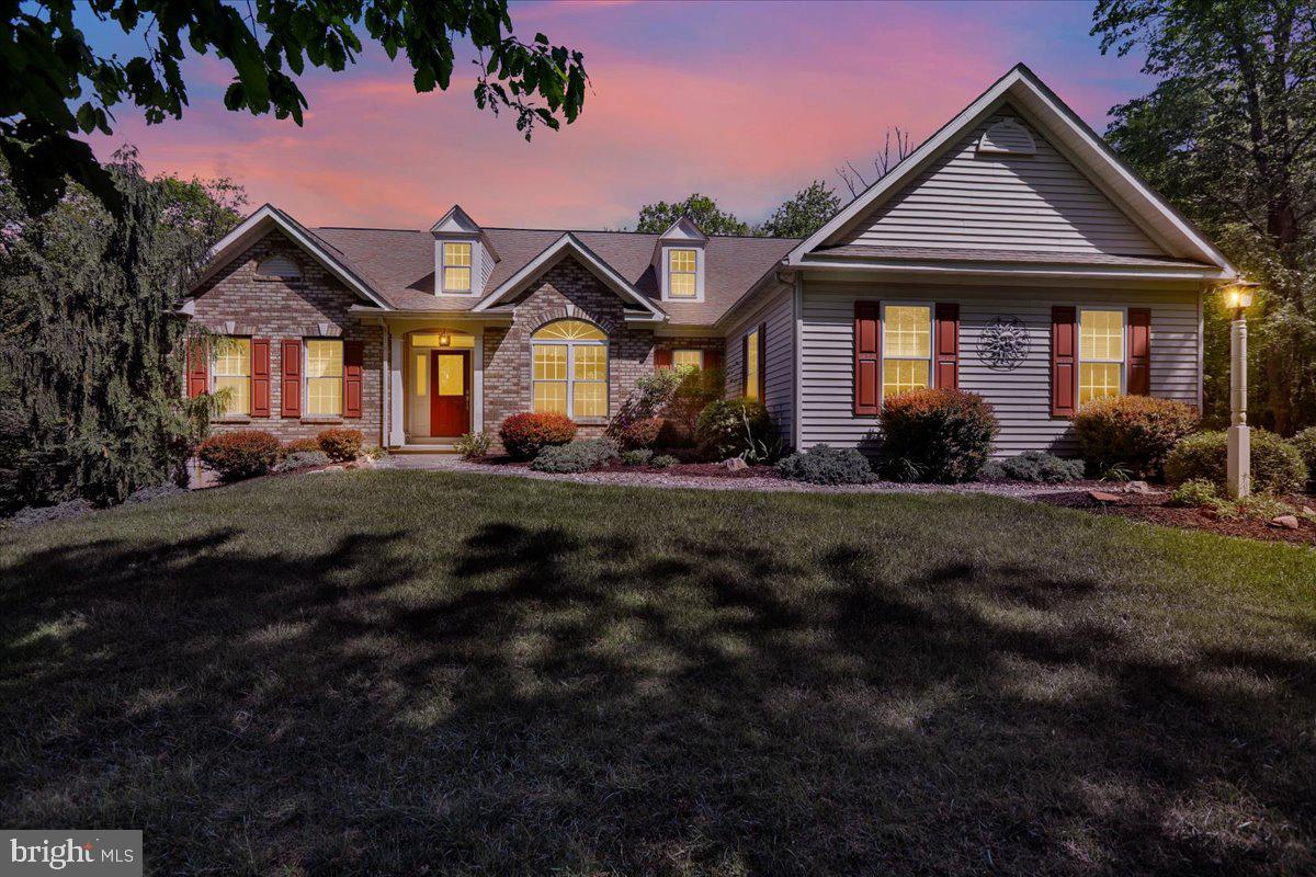 Set amid the wooded, rolling hills with scenic settings in the established Quaker Hill Community, you will find this lovely rambling ranch home with a stone facade and beautiful curb appeal. The foyer has HW flooring and a leaded glass transom over the front door. The 38 handle dark cherry kitchen cabinetry with granite countertops and tiled backsplash and hardwood flooring is open to the bright and cheerful breakfast area. The great-room has hardwood flooring, a cathedral ceiling and a propane fireplace. The formal dining room has portrait molding and a modified tray ceiling. There is a first floor laundry room with a utility sink. Wainscot paneling is on the hallway walls leading to the 3 car SE garage. The primary bedroom features the 2nd propane fireplace, walk-in closet and a cathedral ceiling and an ensuite bathroom. which has a soaking tub and 4' stall shower and a double bowl vanity. Two generously sized bedrooms and a full bathroom are on the opposite side of the home. The daylight, walk-out, finished lower level provides plenty of light to the rec room, another full bathroom and still has plenty of storage area. The HVAC system was new in 2022, and the propane hot water heater was new in 2023. Another area of the basement has a hard wood floor to be used as you see fit. A new trex deck was added last year. This unique community on a wooded mountain side is just 7 minutes to the PA turnpike entrance and close to Rt's 10, 23 and 176, making it an easy commute to Chester County, Lancaster County and Berks County.
