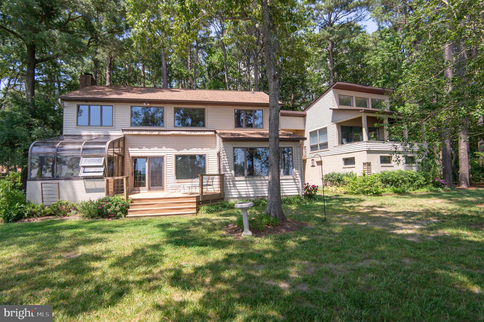 Stunning Waterfront Contemporary on Church Creek
Tucked away on a serene, pine tree-lined drive, this meticulously maintained and architecturally striking waterfront home offers privacy, comfort, and refined craftsmanship just minutes from Cambridge. Designed for modern living with timeless appeal, the property boasts breathtaking views, southern exposure, and a protected shoreline with rip-rap and living shore features—perfect for nature lovers and water enthusiasts alike.
The thoughtfully designed main residence features a first-floor primary suite, glowing wood floors, a cozy gas fireplace, and an upgraded kitchen with granite countertops and a sunny breakfast area. Energy efficient geo thermal heat system.. Upgraded cedar impressions siding. Enjoy year-round greenery in the attached greenhouse or relax on the expansive deck with a retractable shade, ideal for entertaining or quiet reflection.
An airy loft area provides flexible space—perfect for guest overflow, a home office, or a fun kids’ bunk area. Custom built-ins throughout offer generous storage and showcase attention to detail at every turn.
The guest quarters include a private 2BR/1BA suite plus kitchen—ideal for visitors or multi-generational living—alongside an attached garage, workshop for your creative or practical needs. Custom 2 story storage building 24 x 20 (720 sq. ft with 2nd floor) with electric service offering additional space for hobbies or secure storage . Additional features include geo-thermal heating (providing perfect all season environmental conditions) and a tankless hot water heater (energy efficient home), a dedicated wine room, and a spacious laundry room.
With its private dock, tranquil setting, and blend of luxury and function, this one-of-a-kind property is a rare opportunity to enjoy Chesapeake living at its finest.
South Dorchester school district.