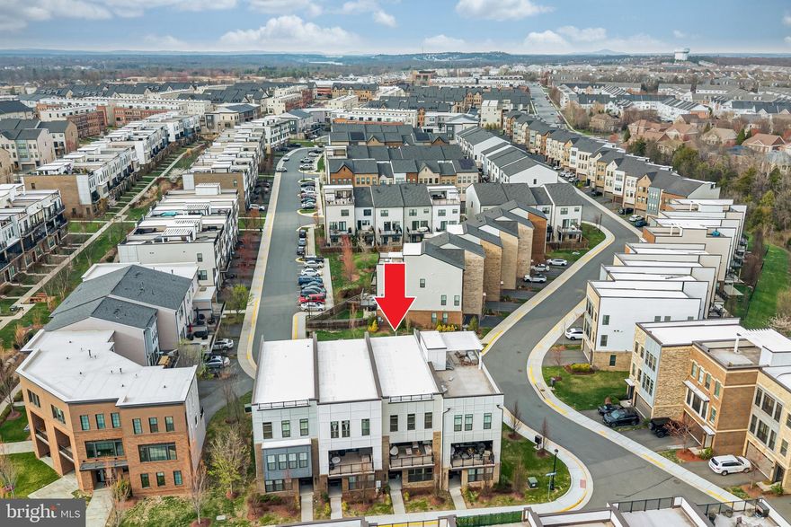 Welcome to this stunning contemporary Teagarden model by Van Metre Homes, An open concept, modern designed residence with 4 bedrooms, 3.5 baths offering nearly 2,850 sq. ft. of thoughtfully designed living space with over $100K in premium builder upgrades. This exceptional 3-level townhome stands out with rare structural enhancements, modern finishes, and a highly desirable, flexible layout designed for today’s lifestyle.

The entry level features a true multi-generational suite complete with a full bath and spacious walk-in closet—perfect for guests, extended family, or a private retreat. This versatile space is pre-wired for a 7.1 home theater system and includes a wet bar rough-in, making it ideal for a recreation room, media lounge, or entertainment hub. Upgraded flooring and elegant oak stairs set the tone for the quality carried throughout the home.

The main level is a game-changer, bright, open, and designed to impress. A chef-inspired gourmet kitchen anchors the space, featuring upgraded stainless-steel appliances, extended quartz countertops, premium soft-close cabinetry, and enhanced lighting. The seamless flow of upgraded hardwood flooring adds warmth and sophistication.

What truly sets this home apart is the rare dual-deck design—one covered deck offering privacy and all-weather enjoyment with the option for automatic shutters, and a second open balcony with unobstructed neighborhood views With sliding glass doors on both sides, this level is flooded with natural light, creating an airy and inviting atmosphere.

A dedicated main-level study provides a quiet and functional work-from-home space—an increasingly rare and valuable feature in townhome living. Custom drapes and upgraded lighting throughout further elevate the home’s modern elegance.

Upstairs, the spacious primary suite offers a luxurious retreat with premium carpeting, an upgraded spa-like bathroom featuring designer tile, a frameless glass shower, rain head shower, dual vanity, and a generous walk-in closet with dedicated his-and-her space. Two additional well-sized bedrooms share a full bath, and a conveniently located upper-level laundry room with front-load washer and dryer adds everyday ease.

The home is complete with a spacious rear-load two-car garage and ample guest parking right in front—another rare convenience.

Ideally located within walking distance to Brambleton Town Center, this home offers unmatched access to dining, shopping, entertainment, the library, and Regal Cinemas. Enjoy nearby parks, scenic trails, playgrounds, and community amenities, all within minutes. Zoned for highly rated schools and just a short drive to major commuter routes and Dulles International Airport.

This is a rare opportunity to own a highly upgraded, move-in ready home with premium features that are hard to find in today’s market. A perfect blend of space, style, and location—this home truly stands apart