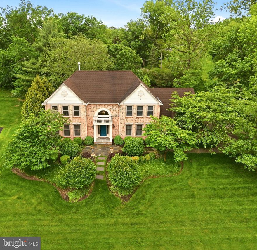 From the moment you step into the soaring two-story foyer, it’s clear this home was designed for both grand entertaining and effortless daily living. Rich hardwood floors guide you through a sophisticated main level where timeless details, like French pocket doors and elegant moldings, set a refined tone. The living room serves as a quiet retreat, featuring custom built-ins that flank an electric fireplace with a handsome wood mantle. Across the hall, the formal dining room offers a stately setting for large gatherings, leading directly into a chef’s kitchen that redefines modern luxury. Anchored by a massive island with leathered granite countertops, this culinary masterpiece is equipped with a Thermador double oven, a custom side-by-side refrigerator and freezer, and a cozy coffee nook perfect for slow mornings. A wall of windows and sliders floods the space with natural light, blurring the lines between the interior and the lush grounds outside. For the ultimate host, the adjacent bar area is a model of convenience, complete with beverage drawers, a prep sink, and a second dishwasher. This hub flows seamlessly into the family room, where integrated surround sound and direct backyard access create an organic indoor-outdoor lifestyle.  Practicality meets polish in the oversized mudroom and laundry suite, which features side-door access to the expanded driveway and entry to the three-car garage, finished with sleek epoxy flooring. Upstairs, the primary suite is a true sanctuary. Raised ceilings with ambient under-lighting and the ease of electric blinds create an atmosphere of pure tranquility. The suite boasts two custom walk-in closets—one featuring a dedicated dressing and makeup vanity—and a spa-inspired bath that rivals a five-star resort, complete with a jetted tub, rain shower, and a rejuvenating steam shower. Three additional bright bedrooms share a beautifully renovated hall bath with a double vanity and contemporary finishes. The living space extends to an incredible finished basement accessed via an elegant French door. Featuring a full kitchen, private office, and a full bath, this level offers the perfect footprint for an in-law suite, guest quarters, or a sophisticated media hub. Outside, the slate patio was thoughtfully designed for accessibility and features a built-in gas grill, ideal for summer evenings under the stars. The expansive, professionally landscaped backyard provides total serenity. With a full-house generator for peace of mind and a location that places you minutes from Germantown Academy, the award-winning Wissahickon School District, and the vibrant dining scene of downtown Ambler, this is more than just a residence—it is a meticulously curated lifestyle.