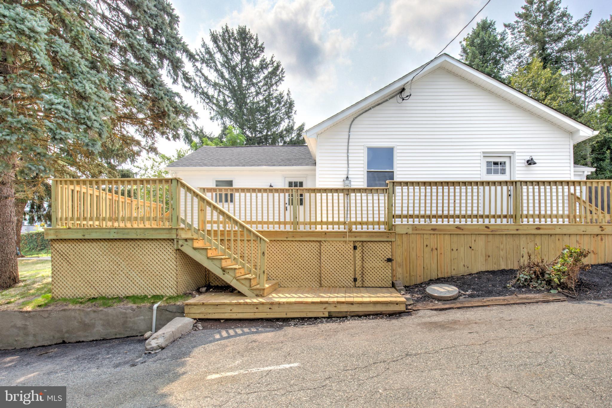 Welcome to 1 Penn Street, a completely renovated ranch-style home nestled in the vibrant borough of Phoenixville, PA—known for its charming downtown, thriving arts scene, and proximity to trails, parks, and major commuter routes! This beautifully updated 3-bedroom, 1-bathroom home features an attractive white siding exterior, a brand new architectural shingle roof, and a spacious rebuilt deck perfect for outdoor entertaining. Inside, the bright main living area showcases refinished hardwood floors, while the adjoining dining and kitchen area offers stylish and durable luxury vinyl tile flooring. The brand new kitchen is equipped with white cabinetry, stainless steel appliances, quartz countertops, and a crisp tile backsplash. All three bedrooms continue the hardwood theme and share a spacious full bathroom with a lovely tiled tub/shower combination. A main floor laundry area adds convenience, and the clean, unfinished basement offers ample storage space. Additional updates include a brand new efficient electric heat pump and water heater, ensuring comfort and peace of mind as well as newly paved asphalt driveway. This move-in ready home blends modern upgrades with cozy charm in a location that truly has it all. Schedule a showing today!